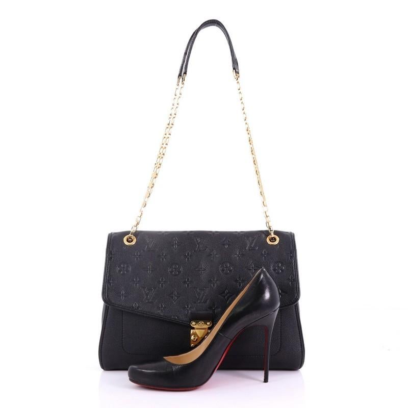 This Louis Vuitton Saint Germain Handbag Monogram Empreinte Leather MM, crafted in black monogram empreinte leather, features chain link strap with leather and gold-tone hardware. Its S-lock closure opens to a black microfiber interior with zip