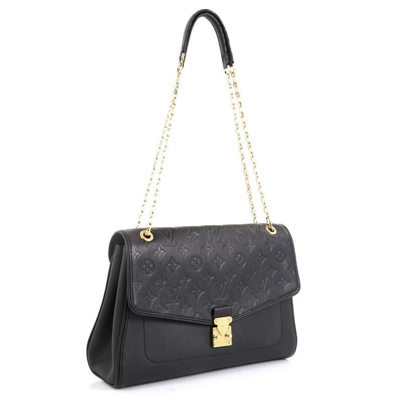 This Louis Vuitton Saint Germain Handbag Monogram Empreinte Leather MM, crafted from black monogram empreinte leather, features chain link shoulder straps with leather pads and gold-tone hardware. Its S-lock closure opens to a black microfiber