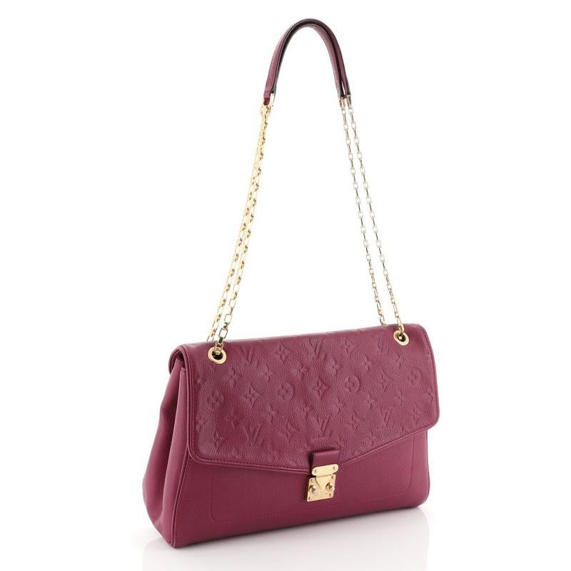 This Louis Vuitton Saint Germain Handbag Monogram Empreinte Leather MM, crafted from purple monogram empreinte leather, features chain link shoulder straps with leather pads and gold-tone hardware. Its S-lock closure opens to a purple microfiber