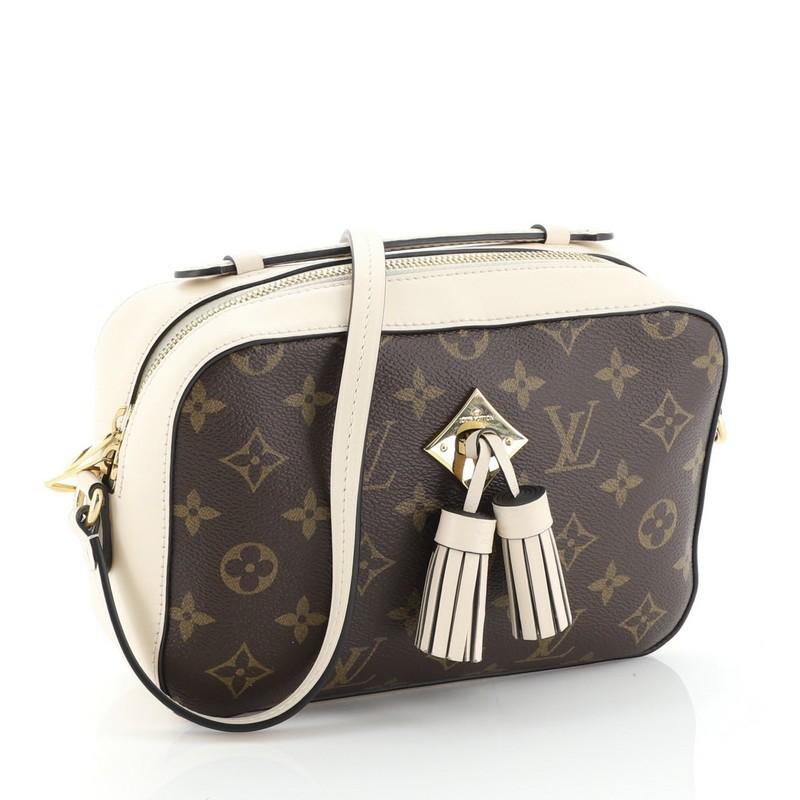 This Louis Vuitton Saintonge Handbag Monogram Canvas with Leather, crafted from brown monogram coated canvas with neutral leather, features top handle and long strap, leather tassels and gold-tone hardware. Its zip closure opens to a neutral fabric