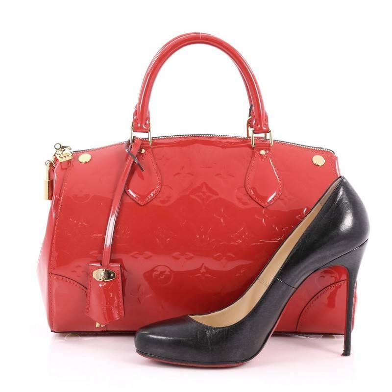 This authentic Louis Vuitton Santa Monica Handbag Monogram Vernis is a gorgeous take on a doctor's bag. Crafted in red monogram vernis leather, this bag features dual-rolled patent leather handles, protective base studs and gold-tone hardware