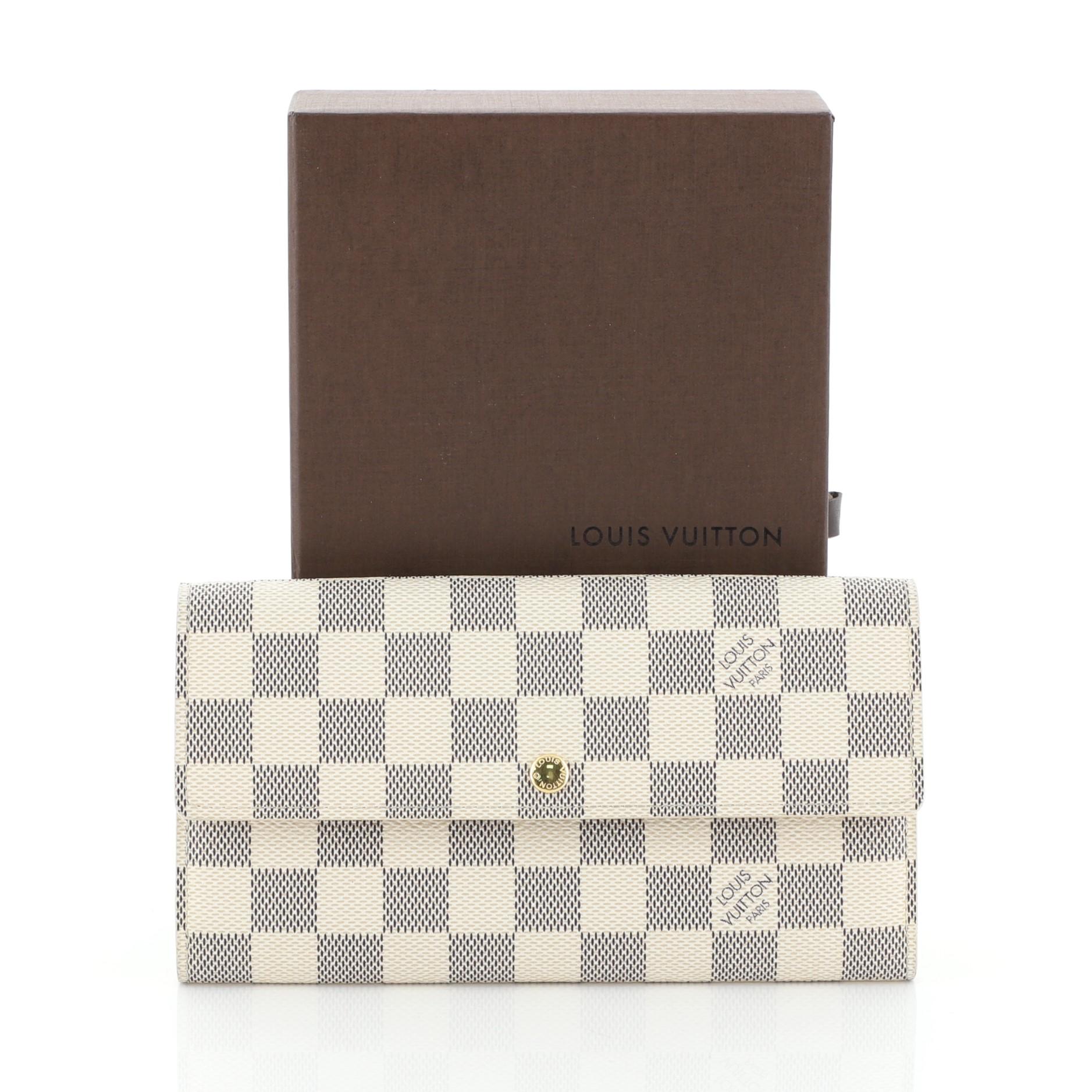 This Louis Vuitton Sarah Wallet Damier, crafted in damier azur coated canvas, features gold-tone hardware. Its snap button closure opens to a white leather interior with middle zip compartment. Authenticity code reads: MI2047. 

Condition: