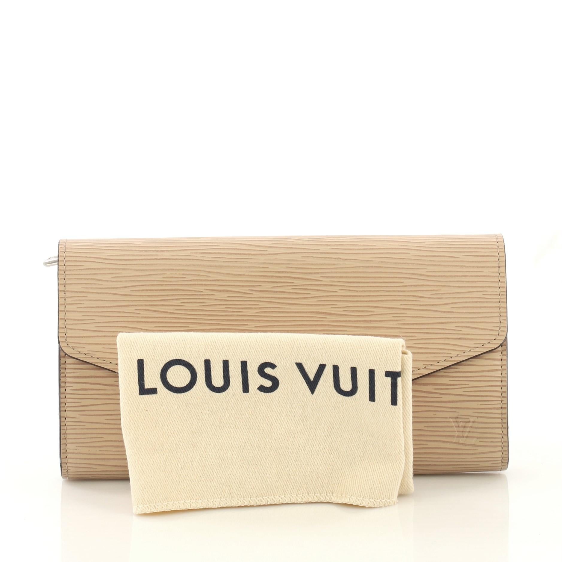 This Louis Vuitton Sarah Wallet NM Epi Leather, crafted in neutral epi leather, features an envelope-style frontal flap and silver-tone hardware. Its snap button closure opens to a neutral leather interior with multiple card slots, slip pockets, and