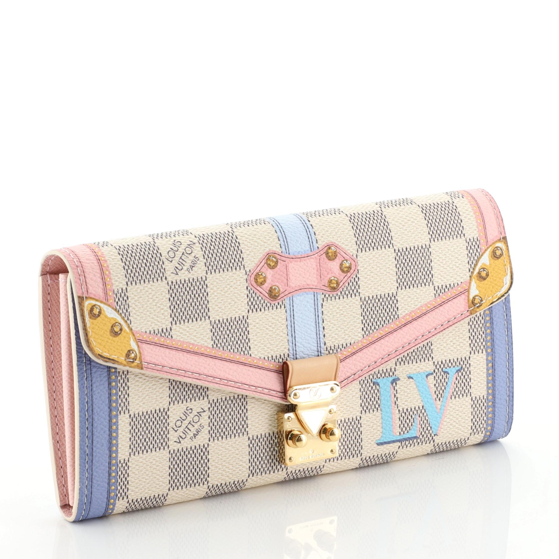 This Louis Vuitton Sarah Wallet NM Limited Edition Damier Summer Trunks, crafted in damier azur coated canvas, features printed trompe-l'oeil pattern and gold-tone hardware. Its S-lock closure opens to a pink leather interior with multiple card