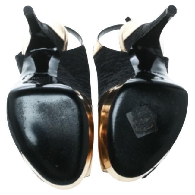 Diese Motard Piccadilly-Sandalen von Louis Vuitton lassen die Herzen höher schlagen und sorgen für Aufsehen in der Menge! Diese Sandalen sind aus schwarzem Satin und goldfarbenem Leder gefertigt und haben eine Peep-Toe-Silhouette. Die Slingbacks mit