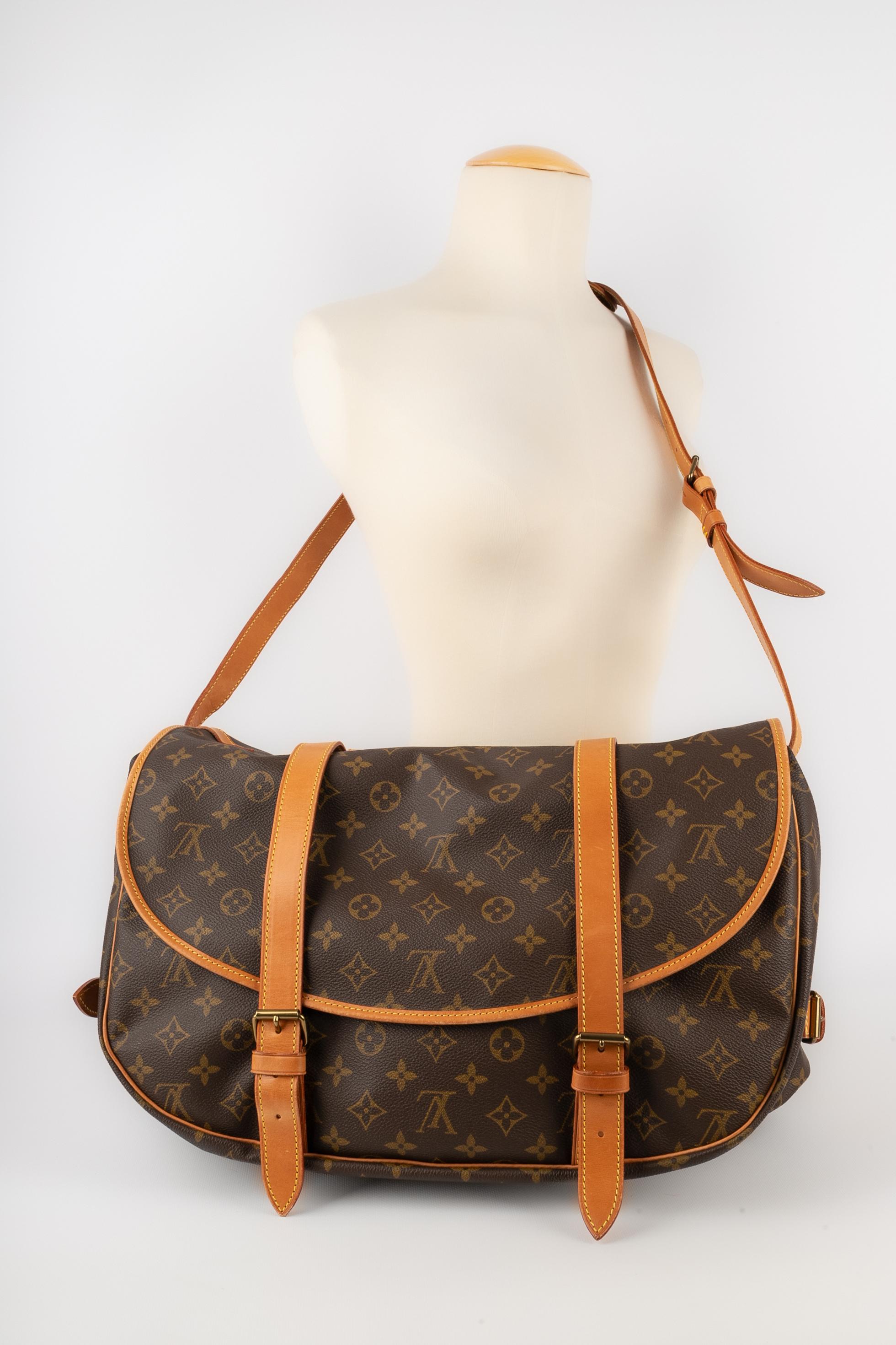 LOUIS VUITTON - (Made in France) Natural leather and monogram canvas 'Saumur' bag. Strap fastening and tab tightening. Adjustable crossbody handle. 1996 Collection.

Condition:
Very good condition

Dimensions:
Height: 27 cm - Width: 41 cm - Depth: