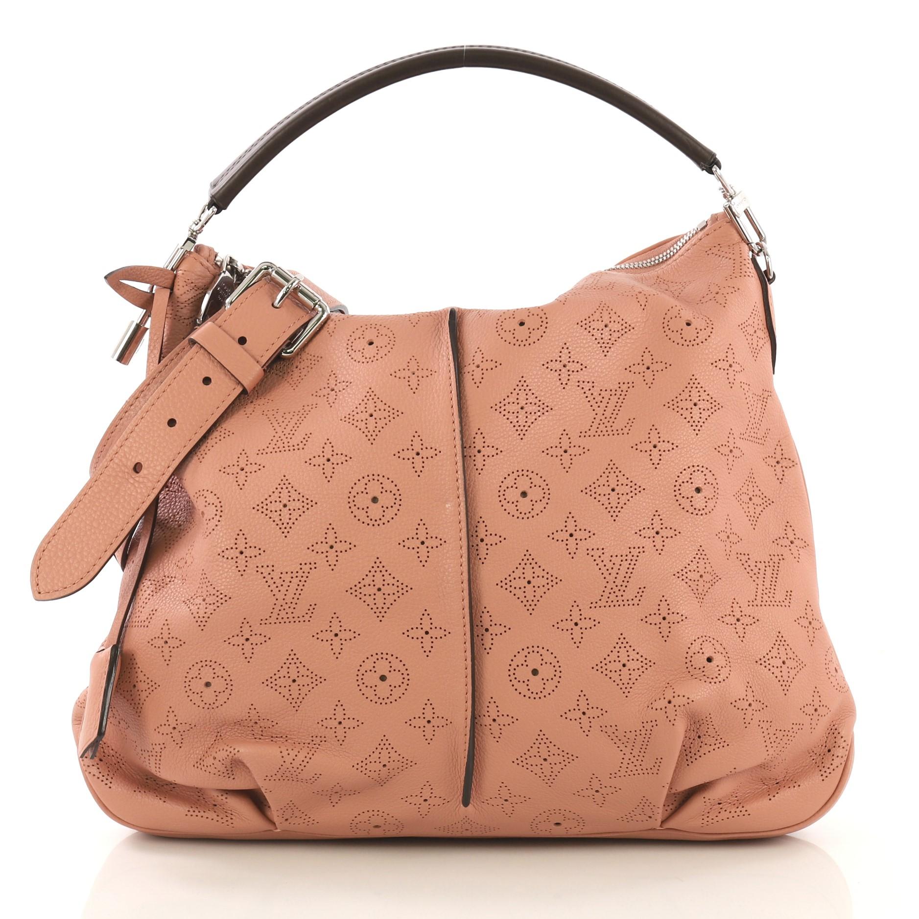 This Louis Vuitton Selene Handbag Mahina Leather PM, crafted from pink monogram perforated mahina leather, features a leather top handle, pleated detailing, and silver-tone hardware. Its zip closure opens to a brown microfiber interior with side zip