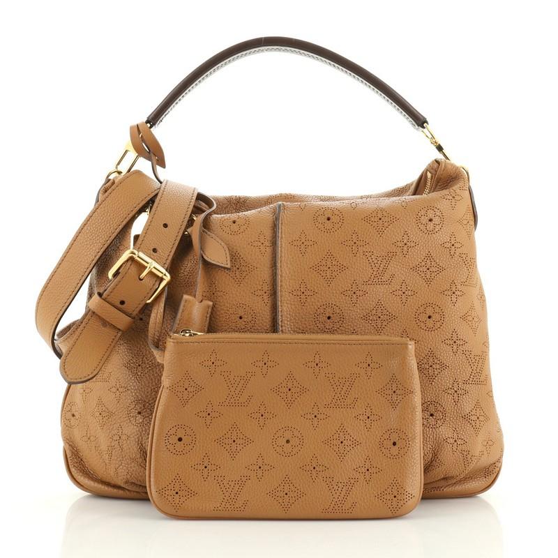 This Louis Vuitton Selene Handbag Mahina Leather PM, crafted from neutral monogram perforated mahina leather, features a leather handle, pleated detailing, and gold-tone hardware. Its zip closure opens to a brown microfiber interior with side zip