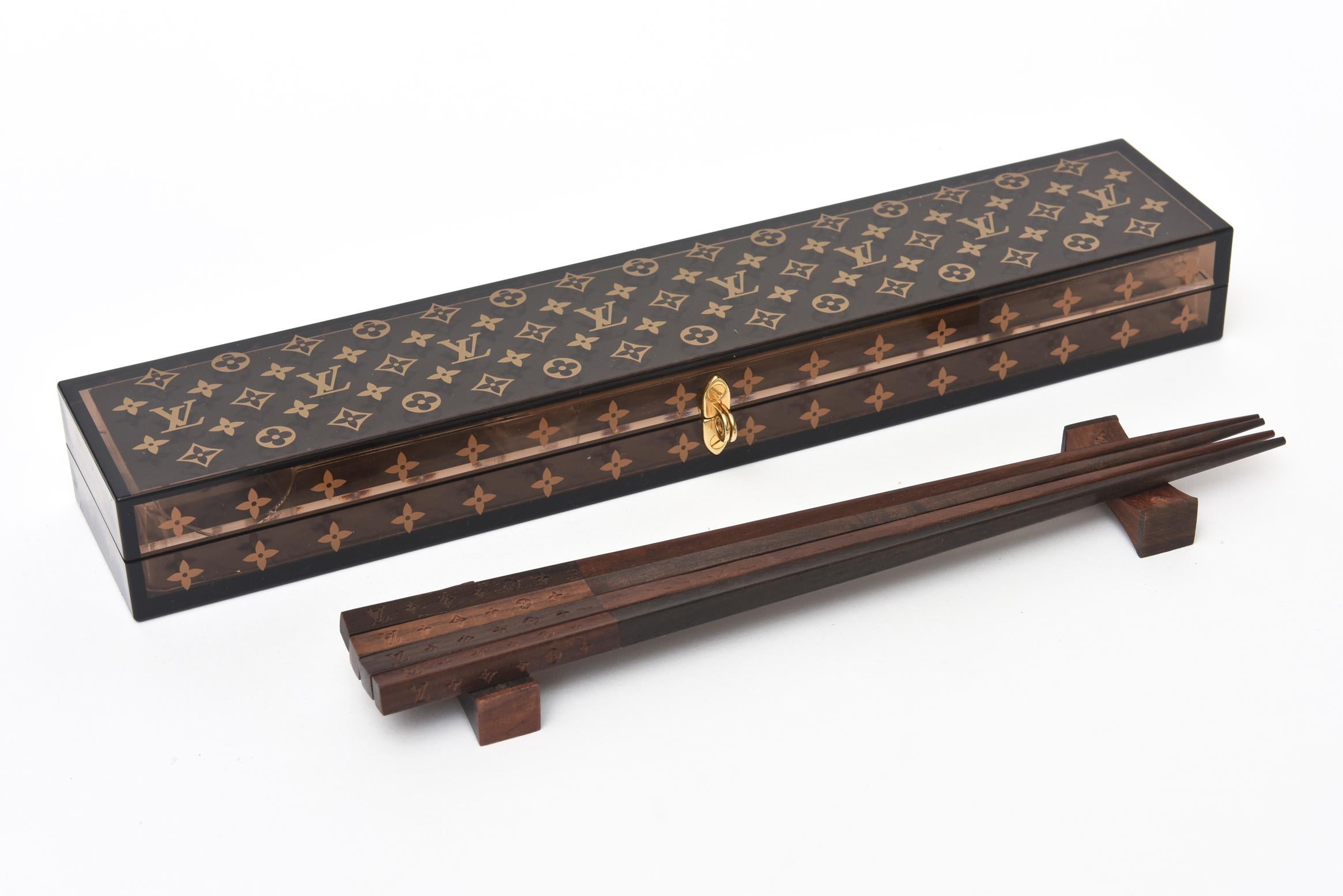This amazing authentic limited edition Louis Vuitton set of a pair of chopsticks with its monogrammed plastic case is from 2012. These have been since discontinued. The pair of chopsticks are monogrammed with the LV at the ends are in two different