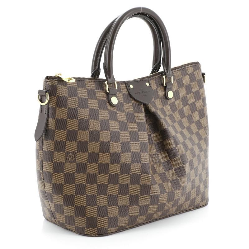 This Louis Vuitton Siena Handbag Damier MM, crafted from damier ebene coated canvas, features dual rolled leather top handles, prominent pleats and gold-tone hardware. Its top zip closure opens to a red fabric interior with slip pockets.