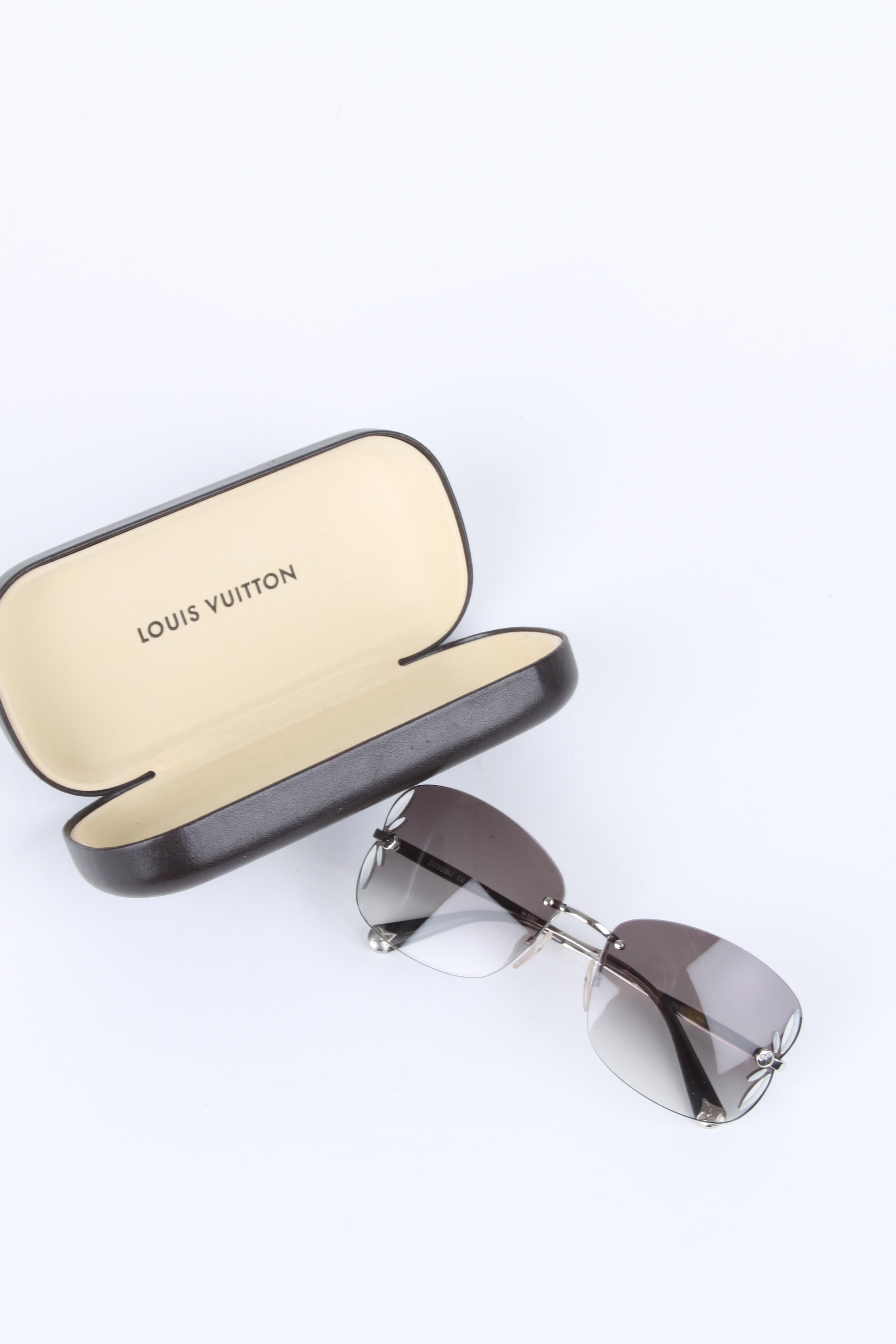 Louis Vuitton Silver/Brown Rimless Lily Sunglasses Z0308U.

These Louis Vuitton Silver/Brown Rimless Lily Sunglasses have a retro but chic appeal. They feature a Monogram flower petal cut out detail on the frames and a frameless design and finishing