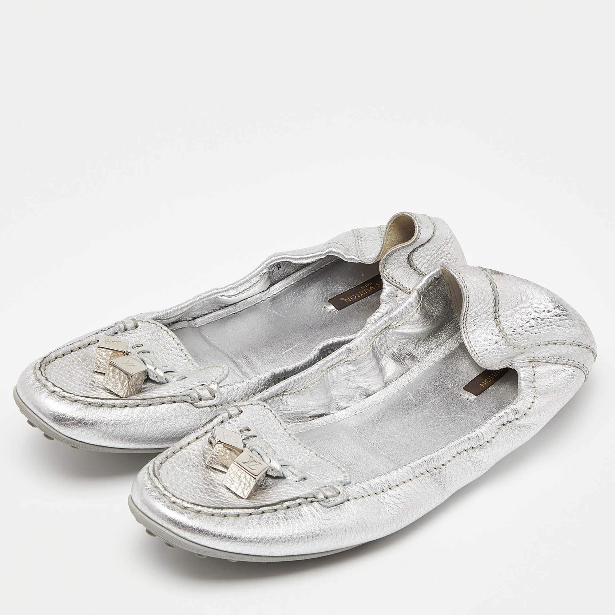 Wear it with your everyday chic casuals or dress it up for work or a party, these beautiful Louis Vuitton loafers are versatile and comfortable stylish. Crafted in silver leather, these loafers feature silver-tone dice and bows on the uppers, a snug