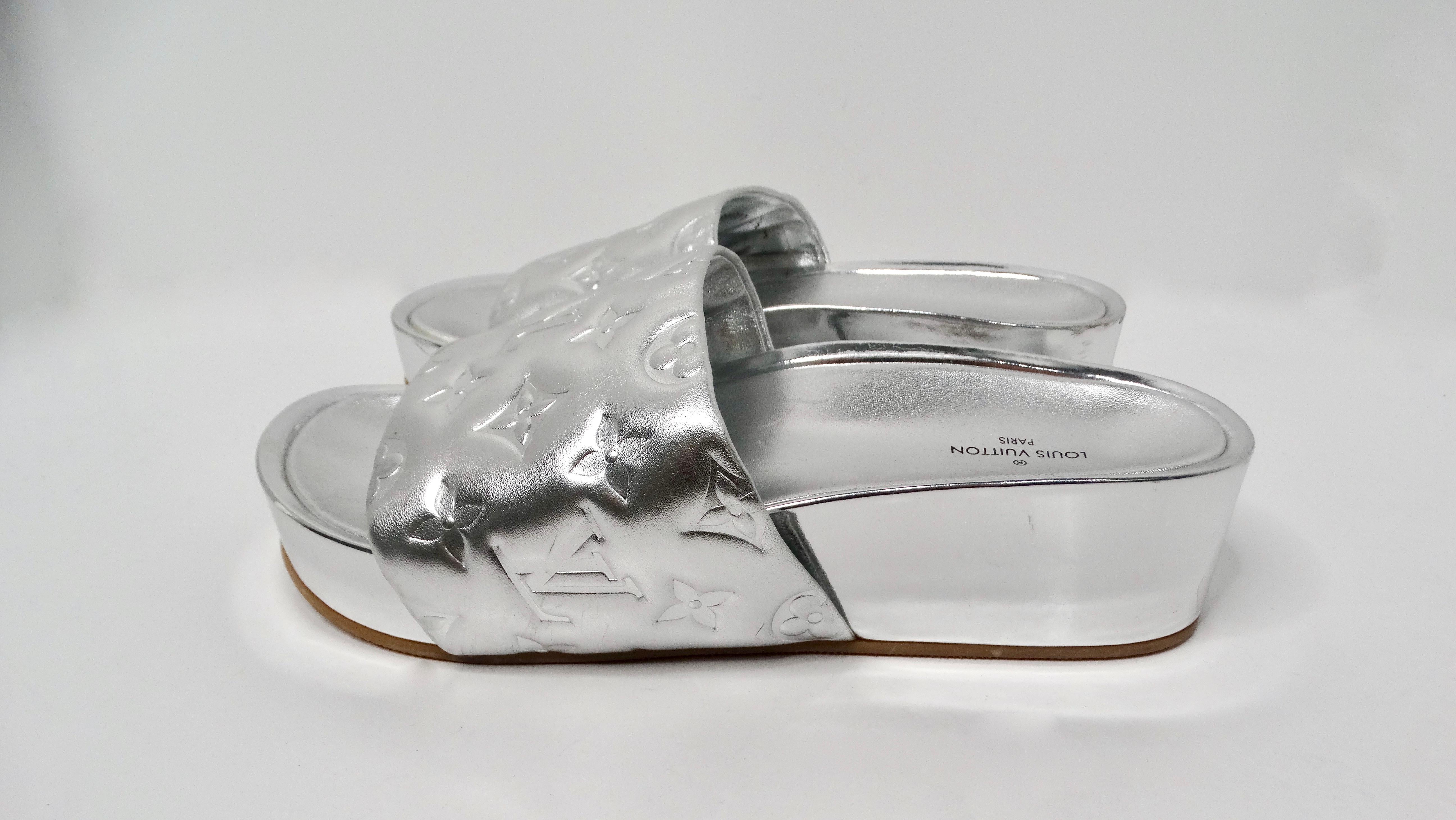 Introducing the Louis Vuitton Silver Metallic Monogram Platform Leather Slide Sandals, a stunning blend of luxury and contemporary design. These sandals feature the iconic Louis Vuitton monogram embossed on high-quality leather, exuding elegance