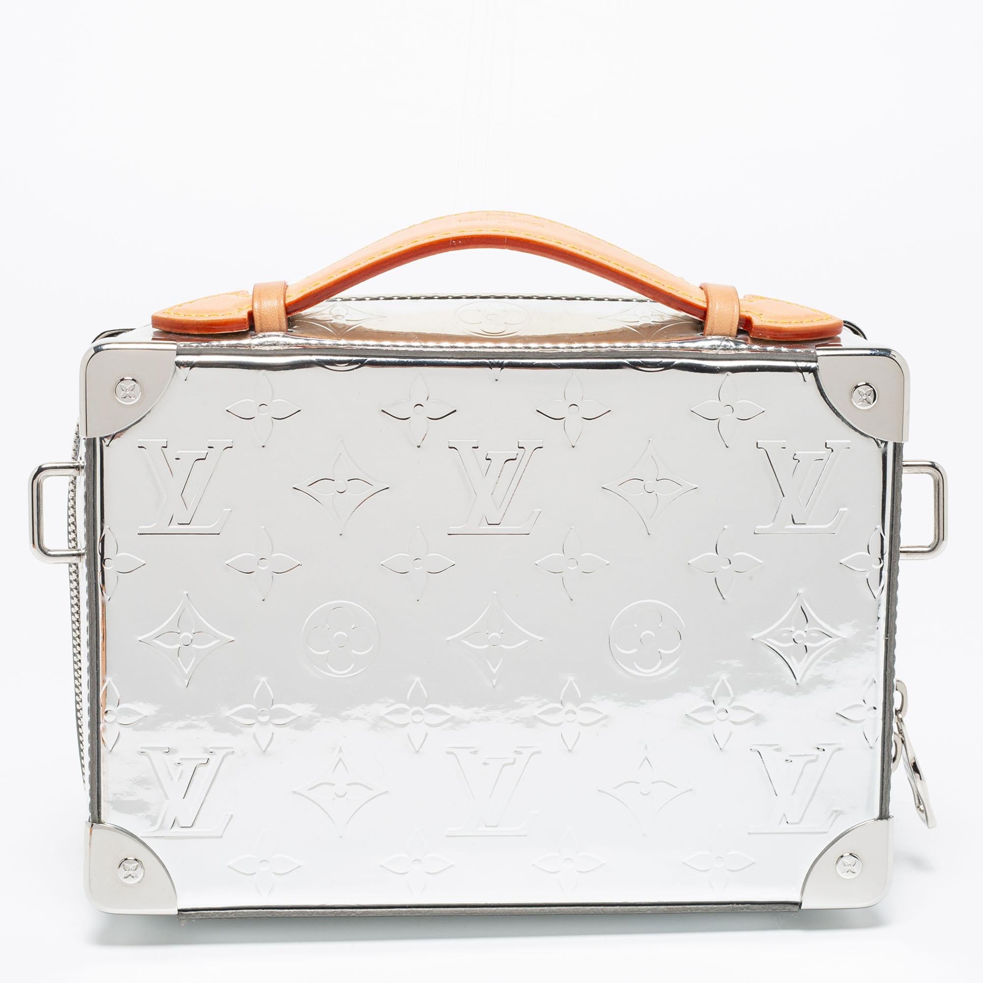 Louis Vuitton's Handle Trunk bag has a modern appeal and a functional quality. Constructed using Mirrored Monogram, the bag has a top handle, a shoulder strap, and a fabric-lined interior.

Includes: Original Dustbag, Original Box, Detachable Strap