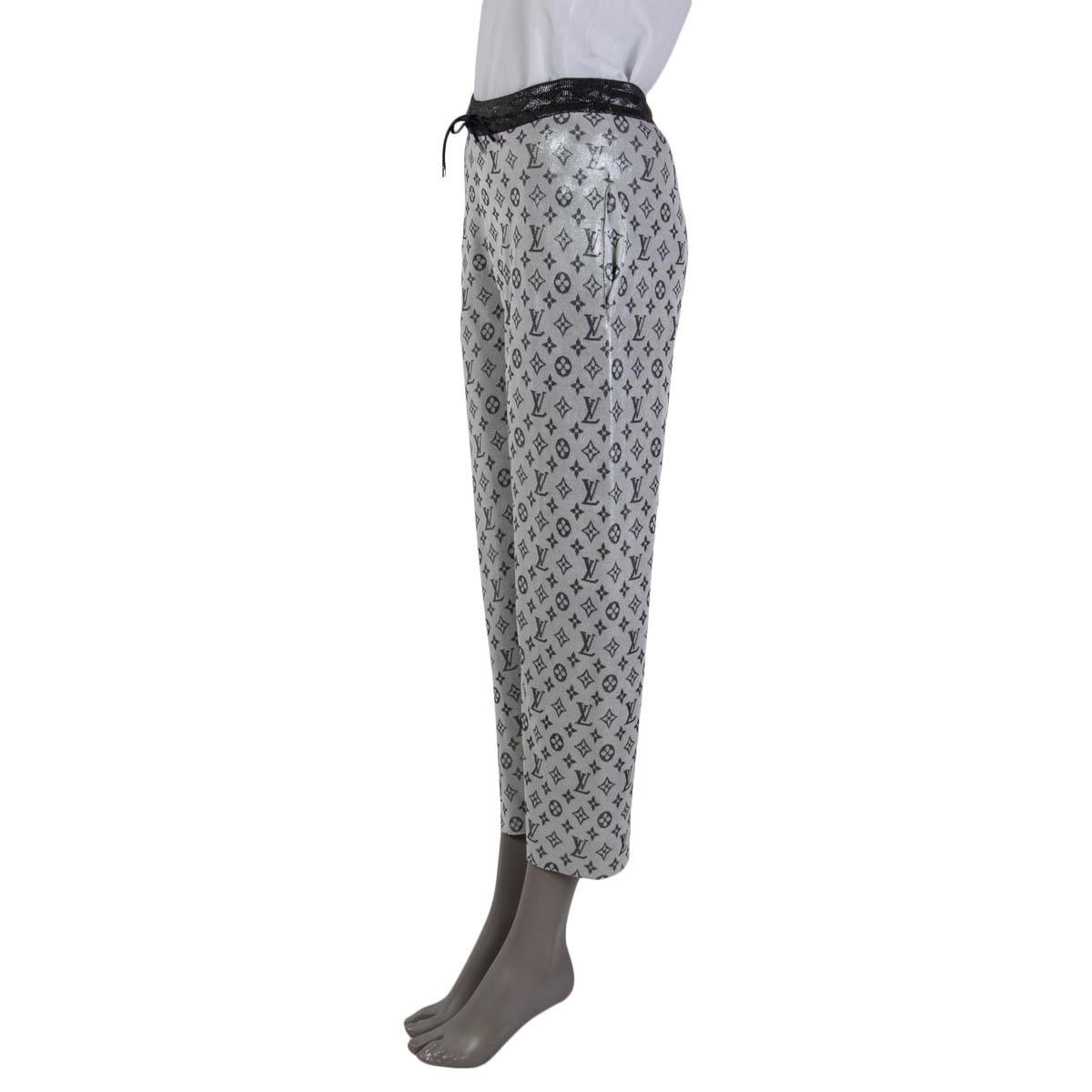 100% authentic Louis Vuitton monogram print lurex knit pants in silver and gray silk (83%) and polyamide (17%). Feature two slit pockets on the side. Open with a drawstring on the front. Unlined. Have been worn and are in excellent