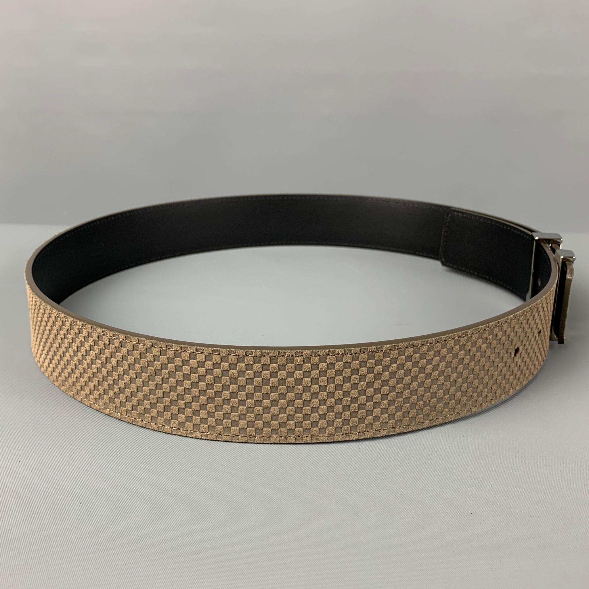 LOUIS VUITTON belt comes in a taupe checkered leather featuring a silver tone logo buckle. Made in Spain. 

Excellent Pre-Owned Condition.
Marked: 85/34 - M9549

Length: 40 in.
Width: 1.5 in.
Fits: 32 in. - 36 in.
Buckle: 1.75 in. 