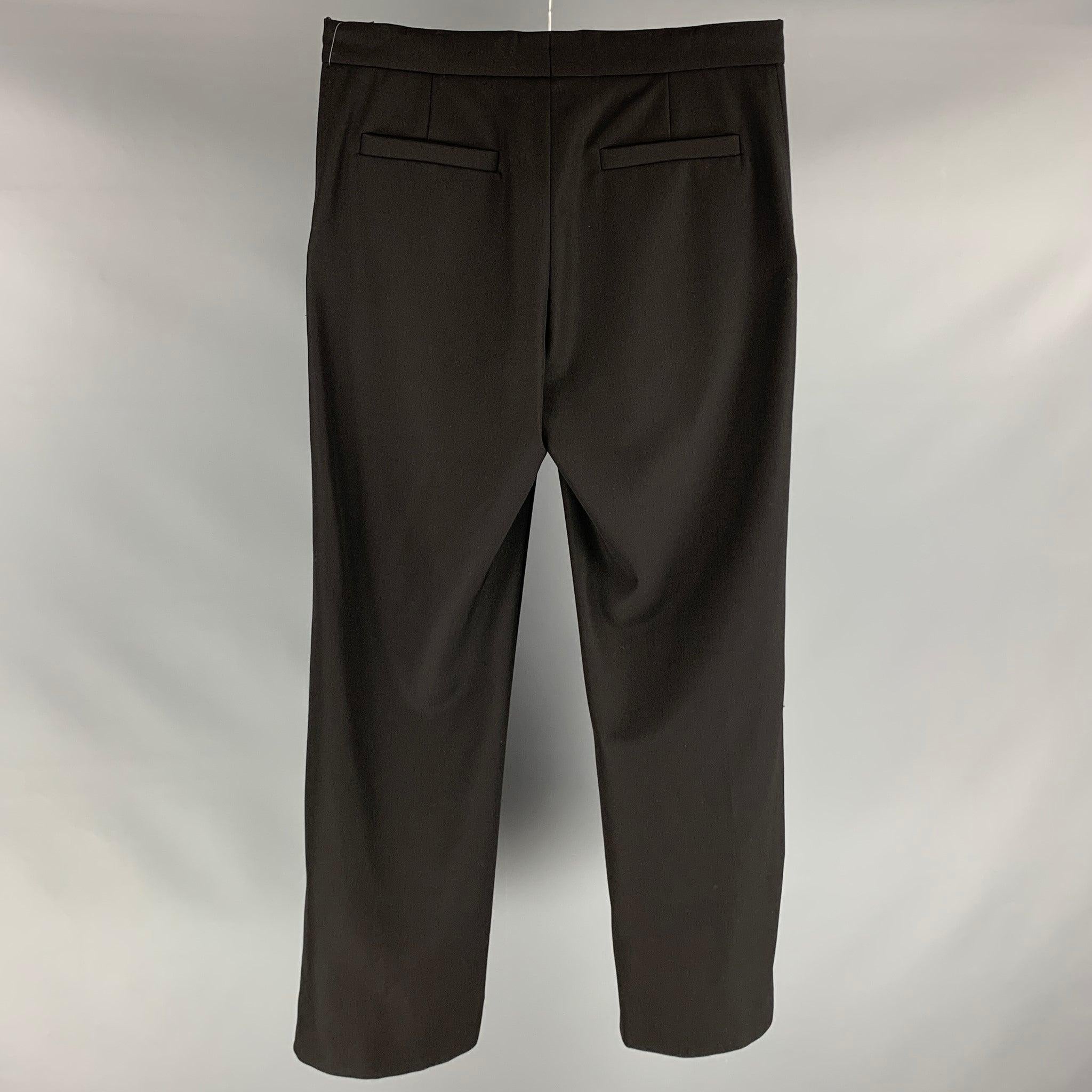 LOUIS VUITTON dress pants comes in a black polyester and wool material featuring a flat front, 3 pockets at front, logo applique detail right leg, medium waist style, front tab, and a zip fly closure. Made in Italy. Excellent Pre-Owned Condition.