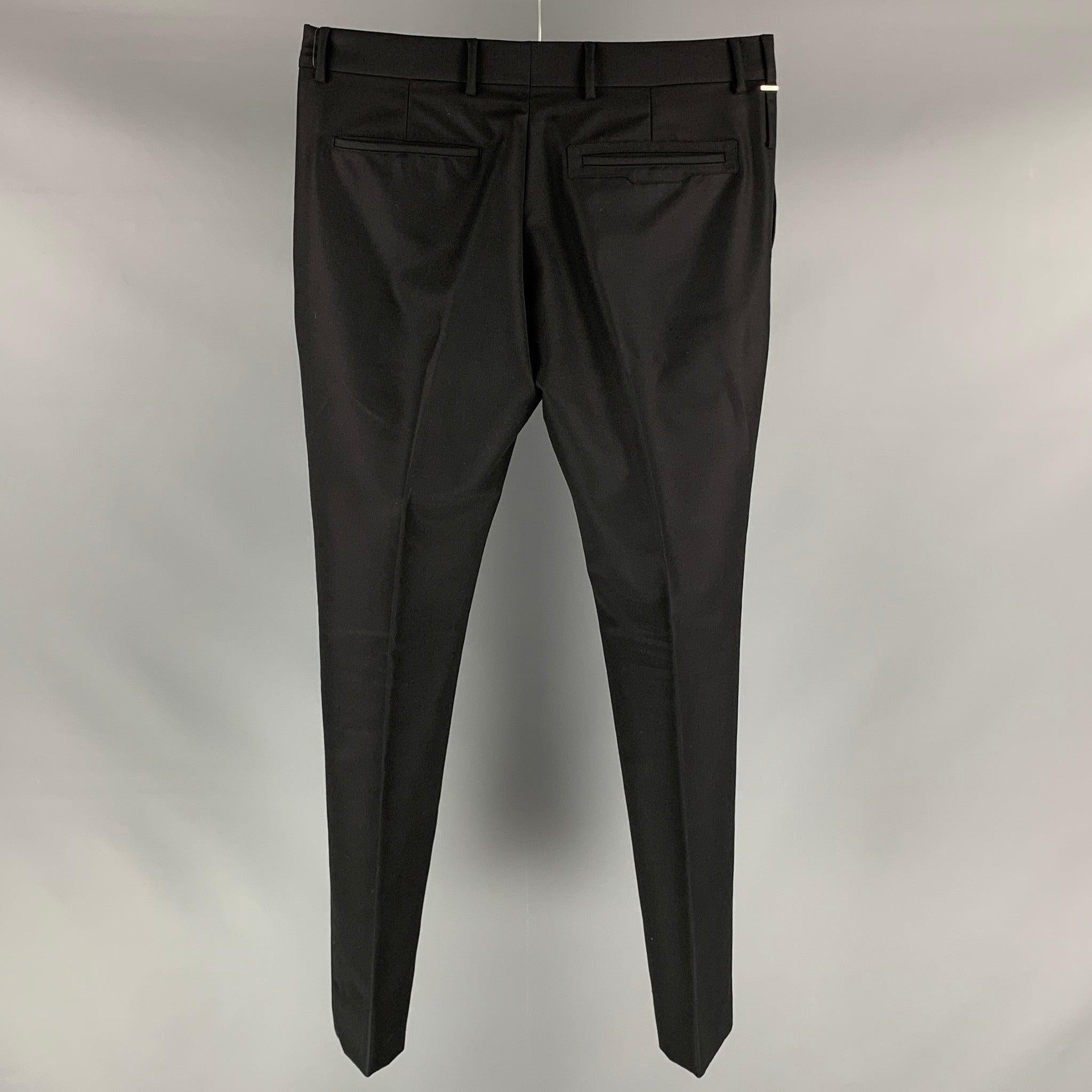 LOUIS VUITTON dress pants comes in a black wool blend material featuring a black loop snap at left leg detail, flat front, front tab, and a button fly closure. Made in Italy. Excellent Pre-Owned Condition. 

Marked:   44 

Measurements: 
  Waist: 37