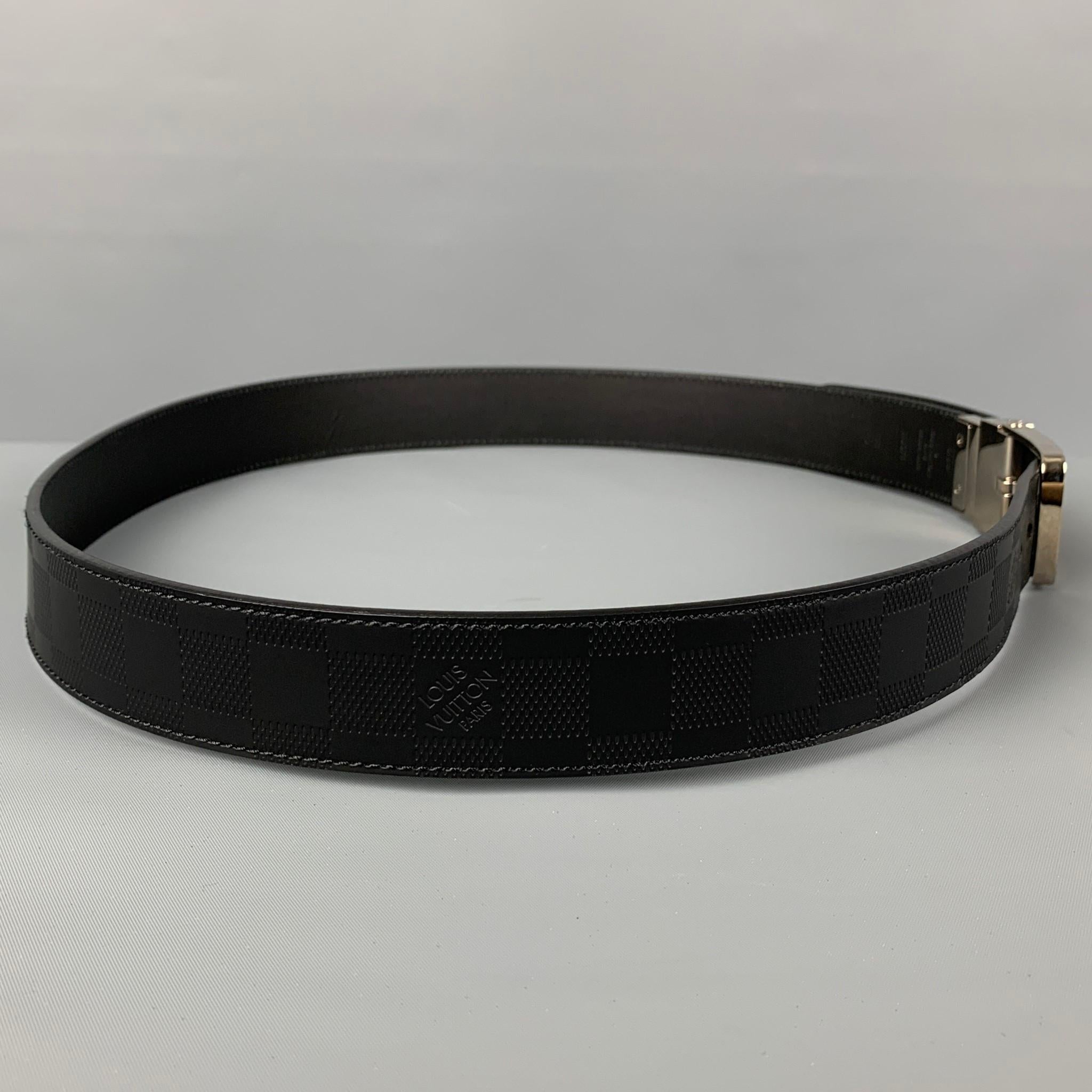 LOUIS VUITTON belt comes in a black damier leather featuring a silver tone buckle. Made in Spain. 

Very Good Pre-Owned Condition.
Marked: 100/40 - M9674

Length: 44 in.
Width: 1.25 in.
Fits: 34.5 in. - 38.5 in.
Buckle: 2 in. 