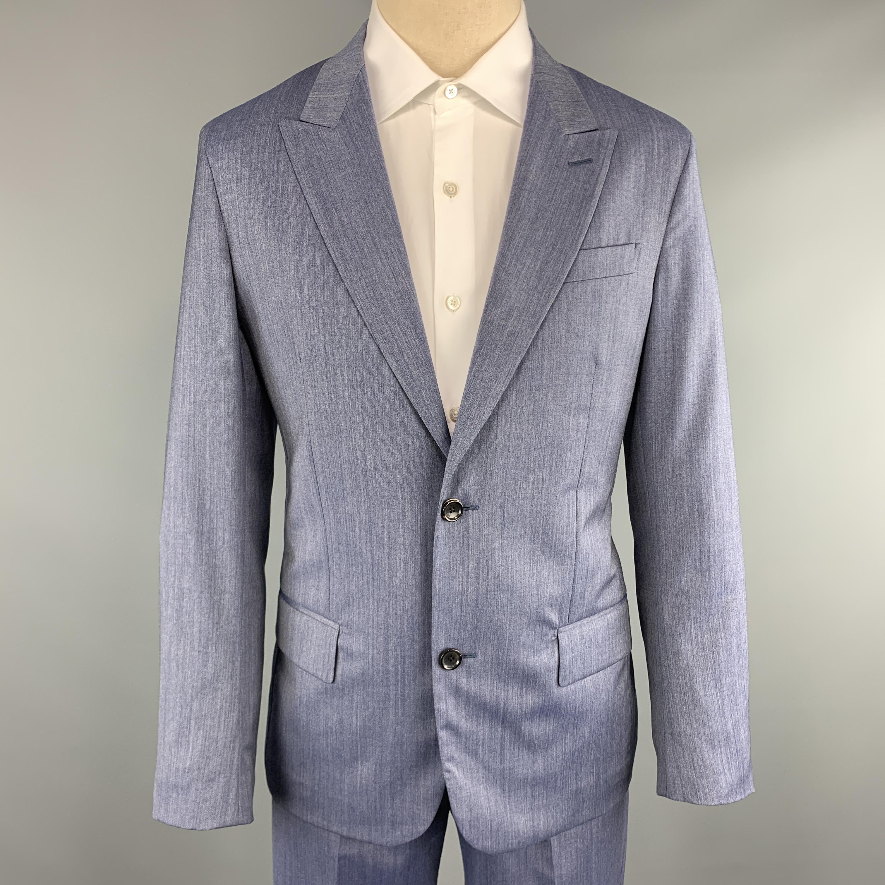 LOUIS VUITTON suit comes in denim blue colored heathered textured sharkskin wool and includes a single breasted, two button sport coat with a peak lapel and matching flat front trousers with LV tab. With garment bag. Made in Italy. 

Excellent