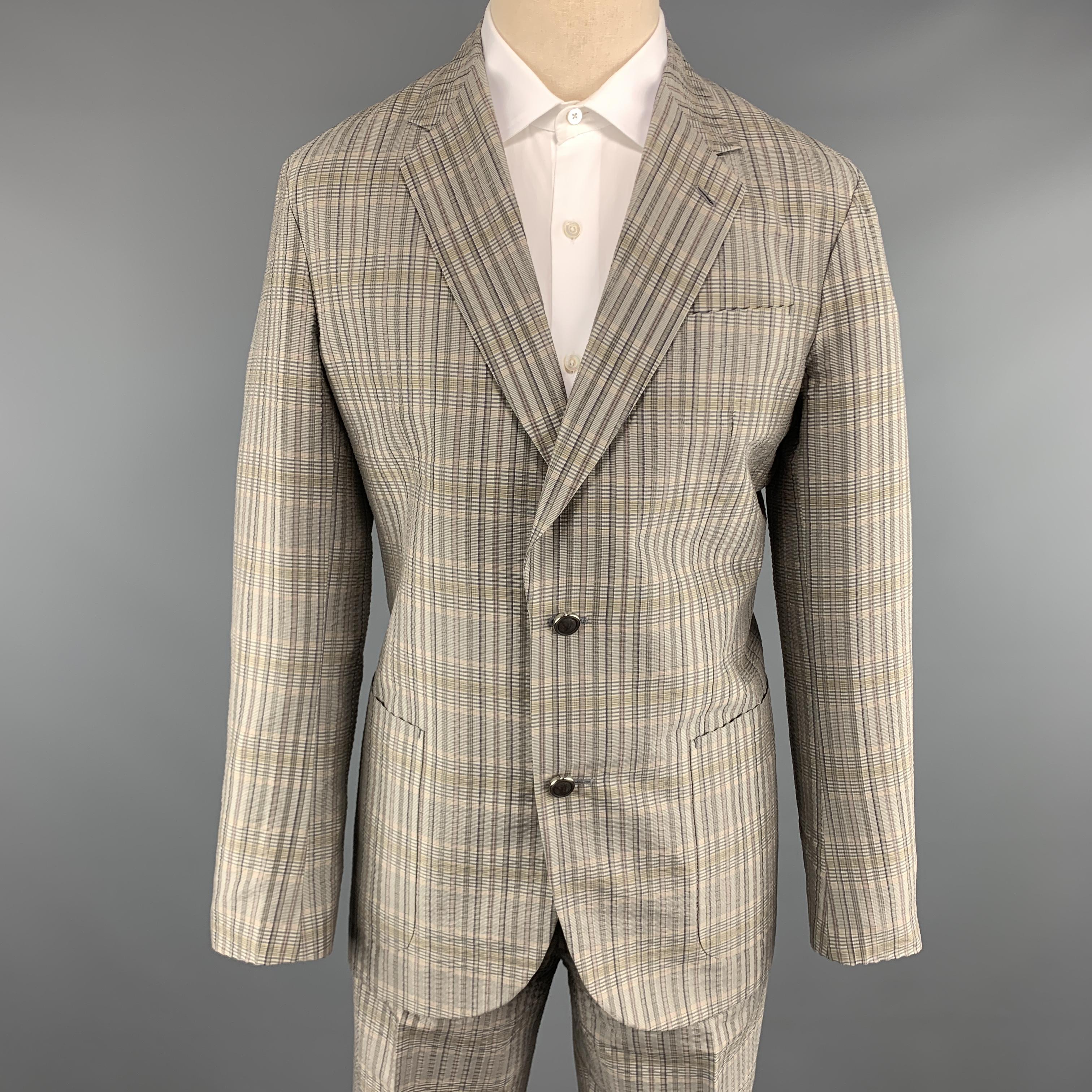 LOUIS VUITTON suit comes in silver gray textured silk with a muted plaid pattern throughout and includes a single breasted, two button sport coat with functional button cuffs, notch lapel and matching flat front trousers. With garment bag. Made in
