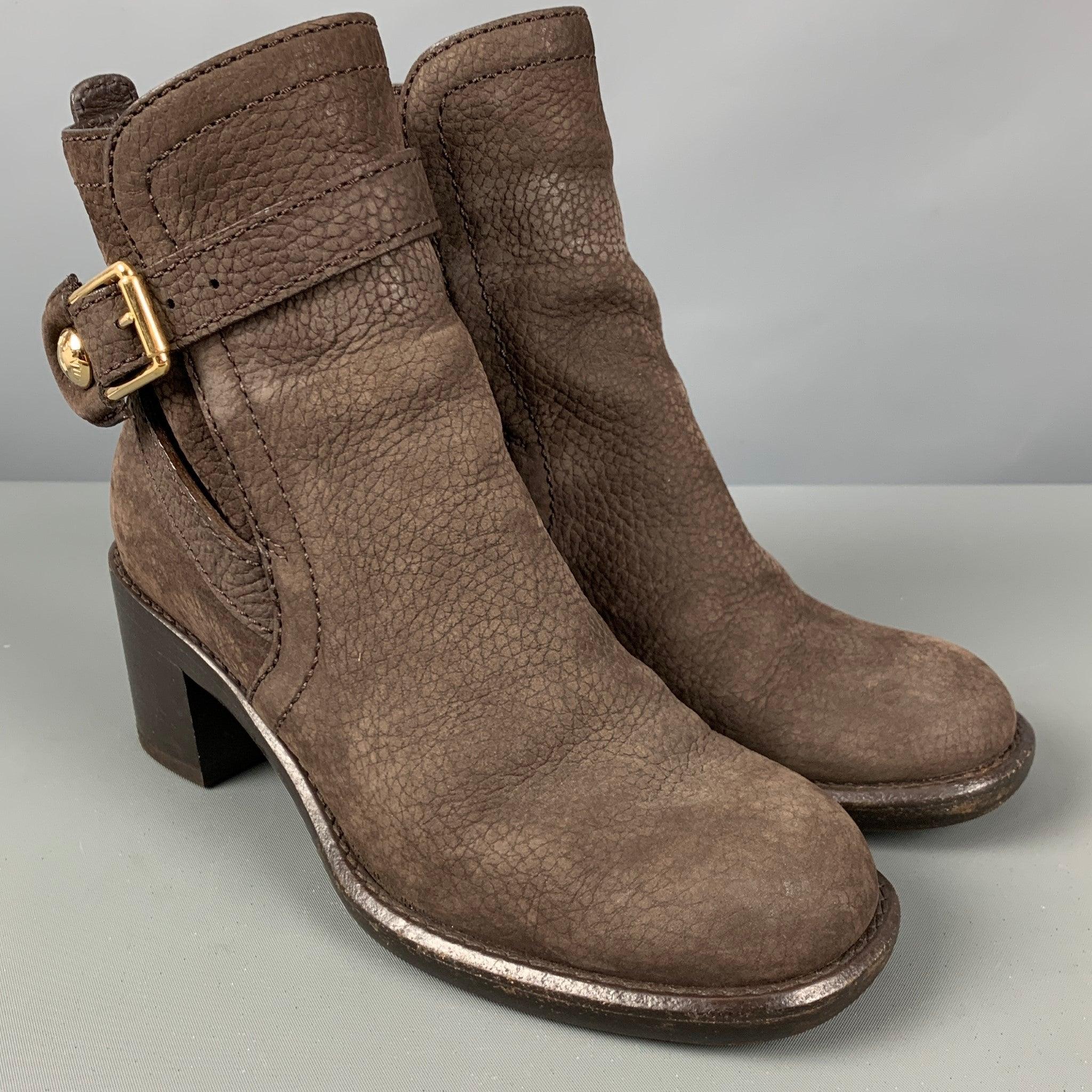 LOUIS VUITTON boots in a brown leather featuring a pebble grain texture, gold tone hardware, chunky heel, and a wooden sole. Comes with box. Made in Italy.Very Good Pre-Owned Condition. 

Marked:   IT 36.5 

Measurements: 
  Length: 9.5 inches