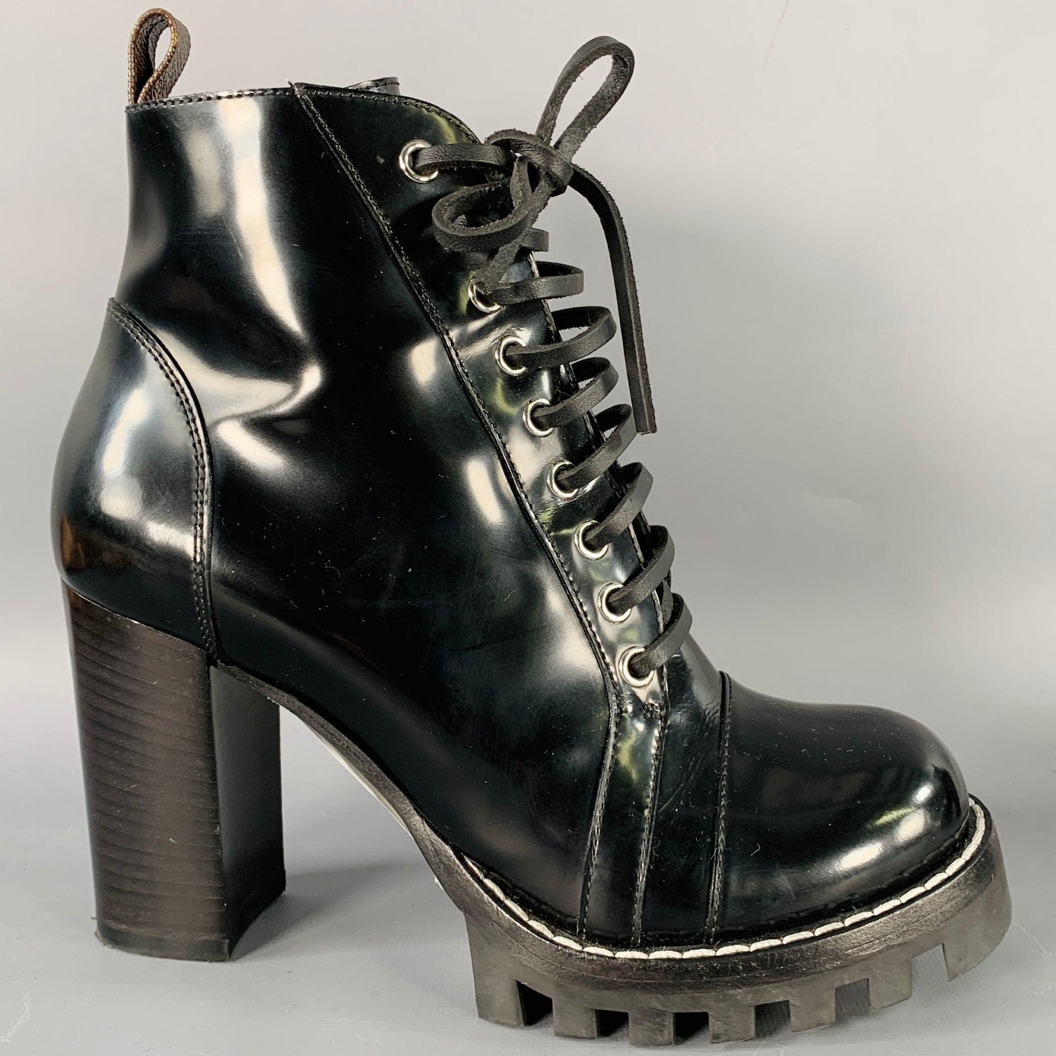 LOUIS VUITTON boots
in a black patent leather featuring an ankle style, cap toe, tread sole with stacked heel, and lace-up closure with side zipper. Made in Italy.Very Good Pre-Owned Condition. Minor creasing at toes. 

Marked:   IT 37.5