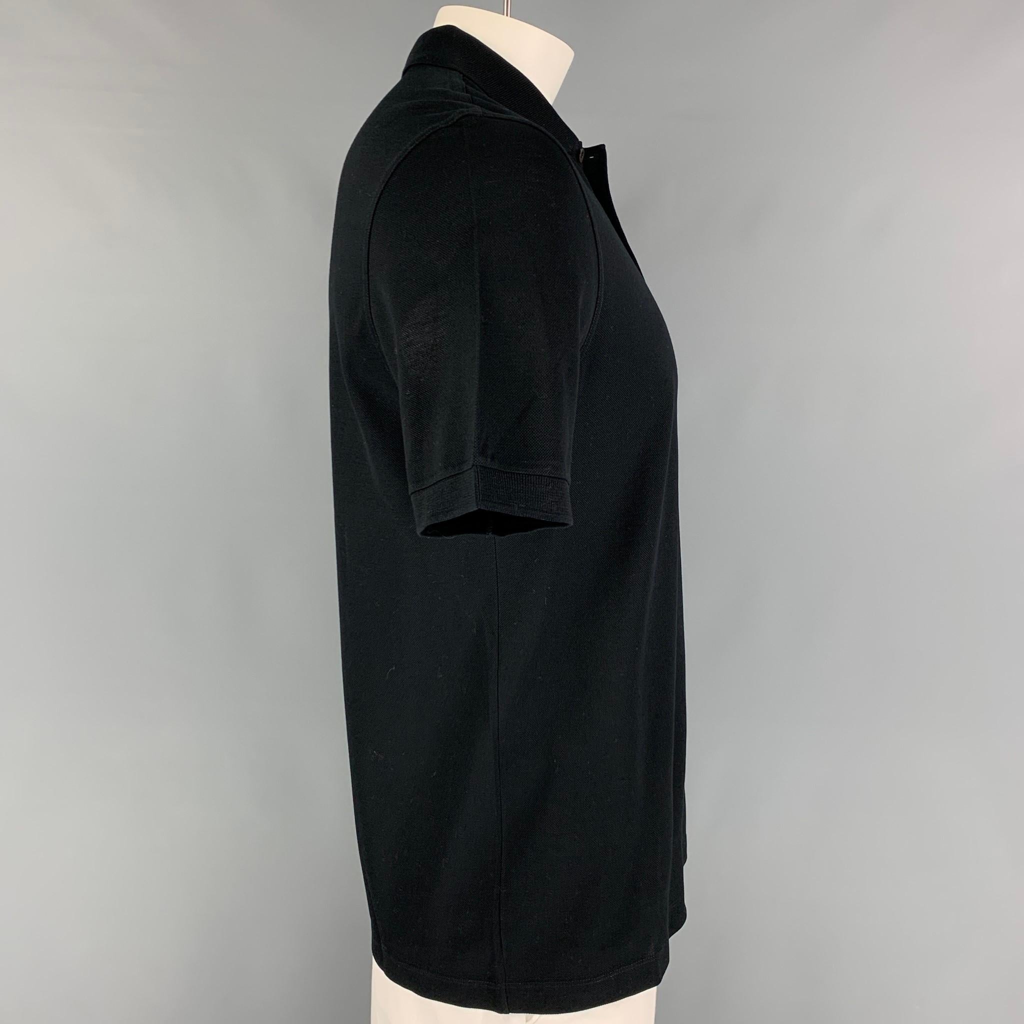 LOUIS VUITTON polo comes in a black cotton featuring a embroidered logo, spread collar, and a half buttoned closure. Made in Italy. 

Excellent Pre-Owned Condition.
Marked: L

Measurements:

Shoulder: 18 in.
Chest: 40 in.
Sleeve: 10 in.
Length: 28