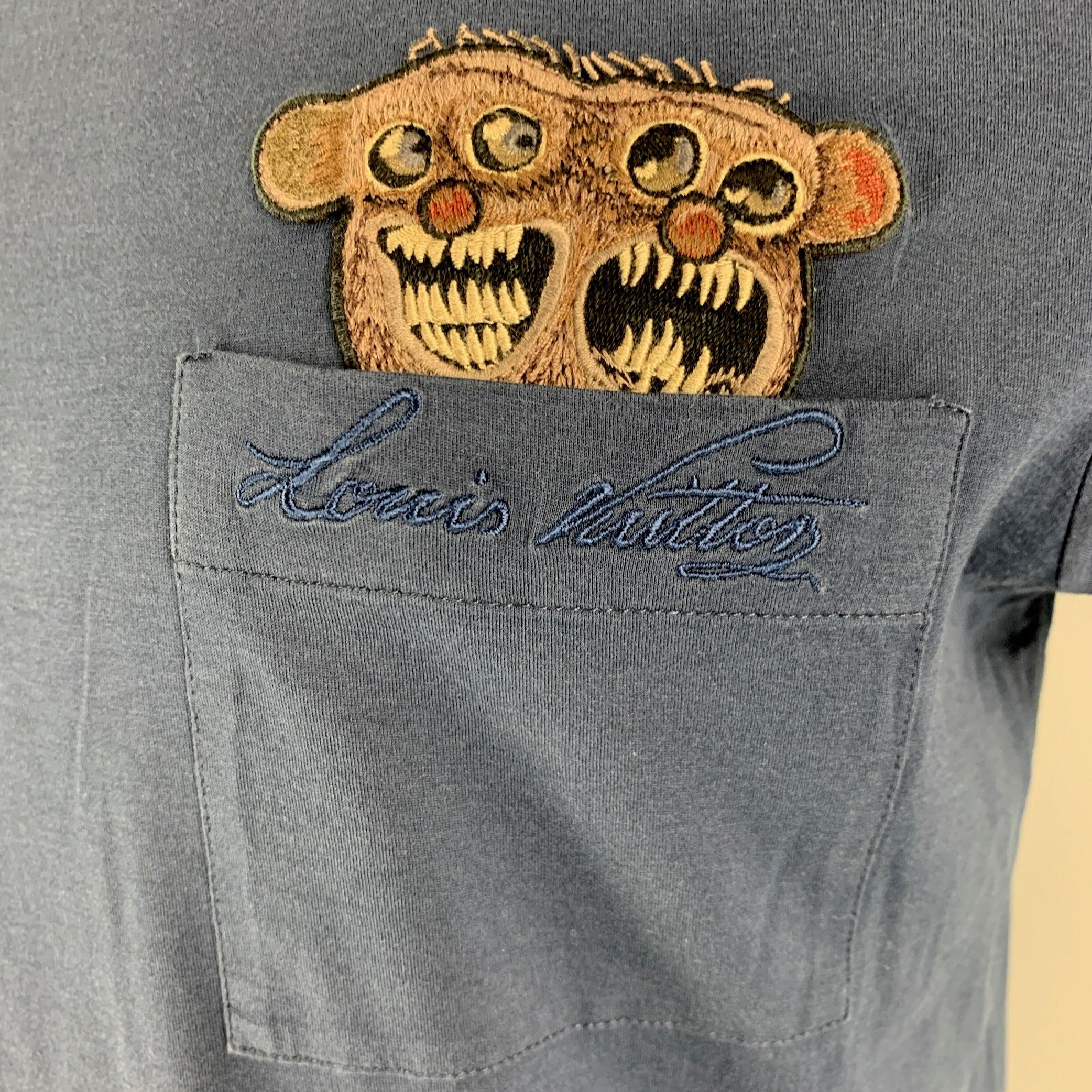 LOUIS VUITTON t-shirt comes in a blue cotton jersey knit featuring crew- neck, front pockets and monster patch applique. Made in Italy.Very Good Pre-Owned Condition. Moderate Color Fading. 

Marked:   M 

Measurements: 
 
Shoulder: 20 inches Chest: