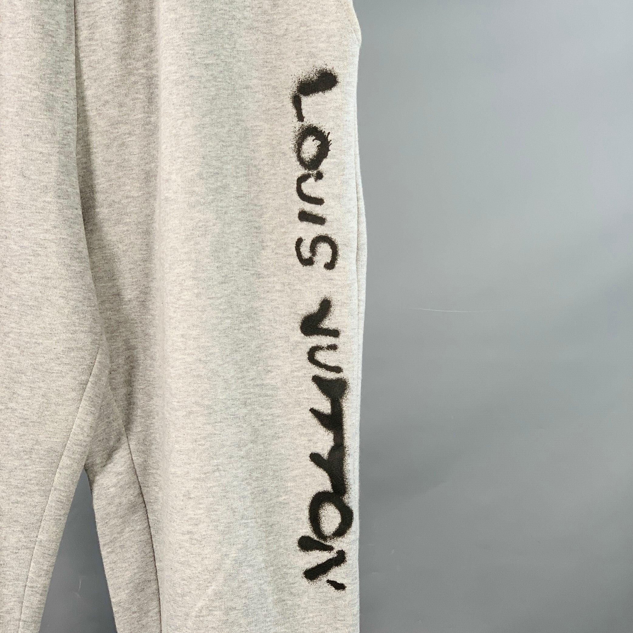 Pantalones de chándal LOUIS VUITTON
en algodón gris jaspeado con logotipo negro estilo graffiti, puños de canalé y cierre de cordón. Made in Italy. Muy buen estado de conservación. Pequeños signos de desgaste. 

Marcado:   M 

Medidas: 
  Cintura: