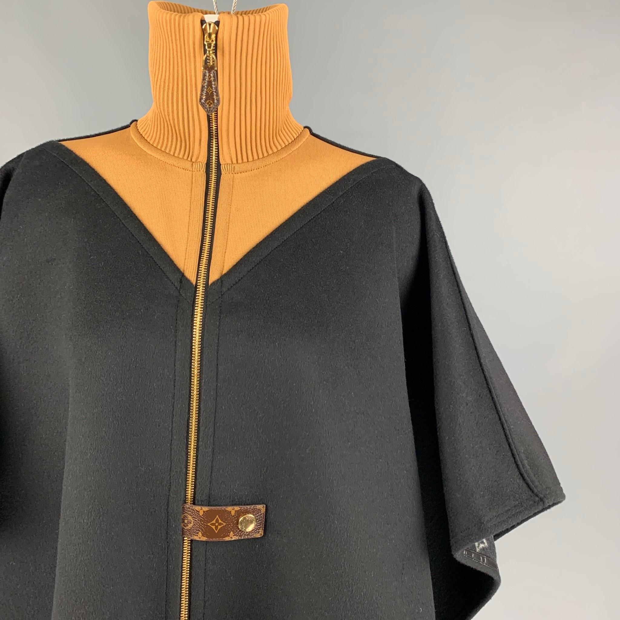 LOUIS VUITTON 'Double Face' cape comes in a black & tan wool / silk with a monogram interior featuring a ribbed high neck, relaxed fit, monogram canvas accents, and a full zip up closure. Made in France. 

Excellent Pre-Owned Condition.
Marked: