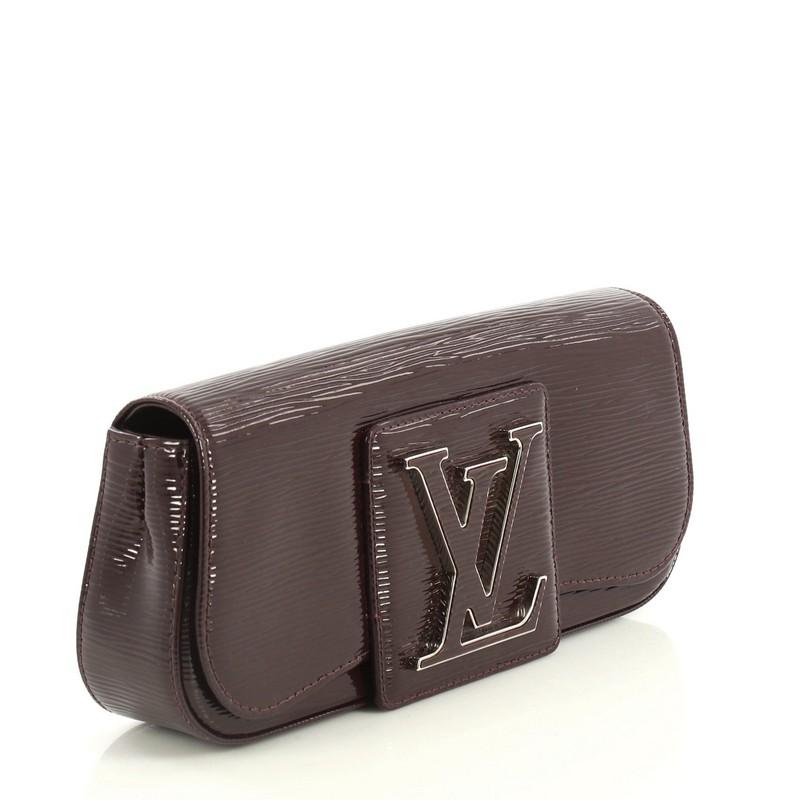This Louis Vuitton Sobe Clutch Electric Epi Leather, crafted in purple electric epi leather, features an oversized LV logo on its flap and silver-tone hardware. Its hidden magnetic snap closure opens to a purple fabric interior with side zip pocket.