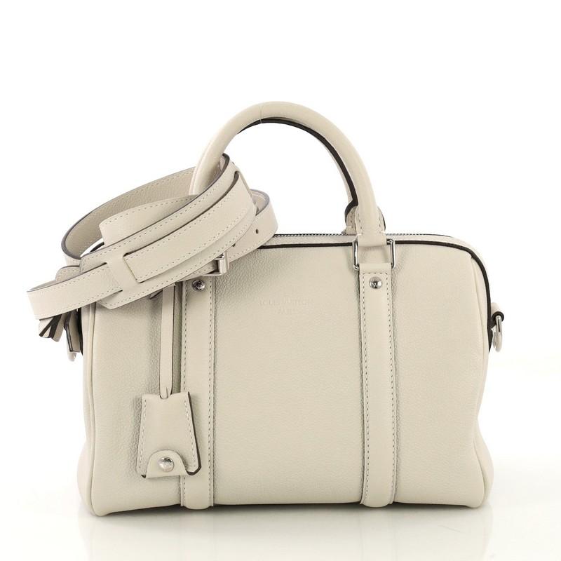 This Louis Vuitton Sofia Coppola SC Bag Leather BB, crafted from off white leather, features dual rolled handles, protective base studs, and silver-tone hardware. Its two-way zip closure opens to a taupe suede interior with side zip and slip