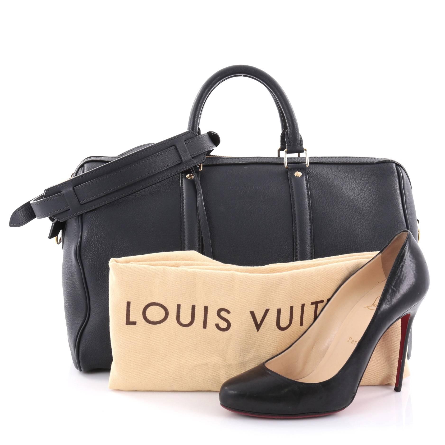 This authentic Louis Vuitton Sofia Coppola SC Bag Leather MM is as stylish and elegant as its designer. Crafted from navy blue leather, this simple yet refined duffle bag features sturdy rolled handles, adjustable shoulder strap, protective base