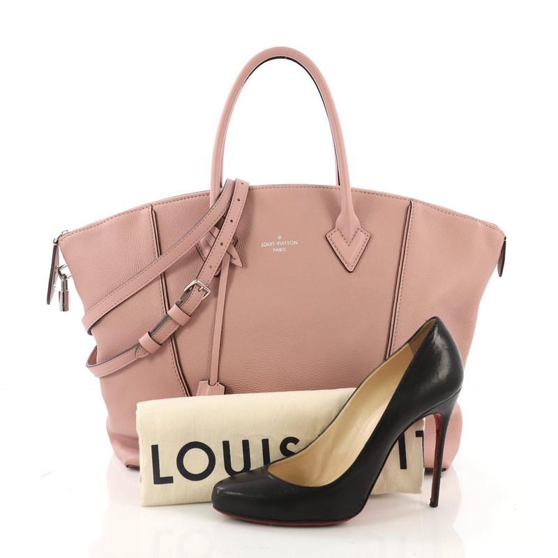 This Louis Vuitton Soft Lockit Handbag Leather MM, crafted from pink leather, features dual rolled handles, curved top, protective base studs, and silver-tone hardware. Its top zip closure opens to a taupe suede interior with side zip and slip