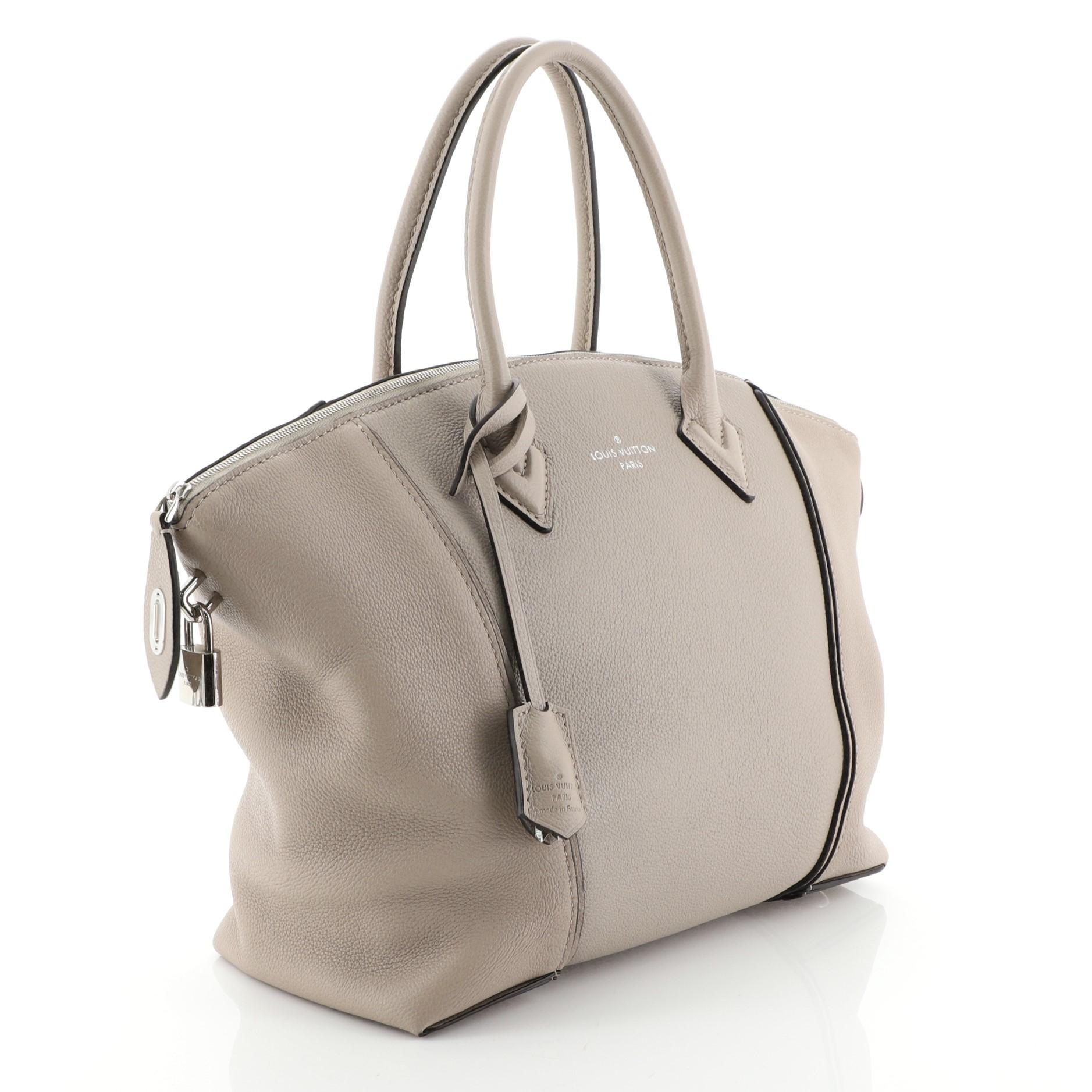 This Louis Vuitton Soft Lockit Handbag Leather PM, crafted from neutral leather, features dual rolled handles, curved top, LV padlock on its side, and silver-tone hardware. Its zip closure opens to a neutral suede interior with zip and slip pockets.