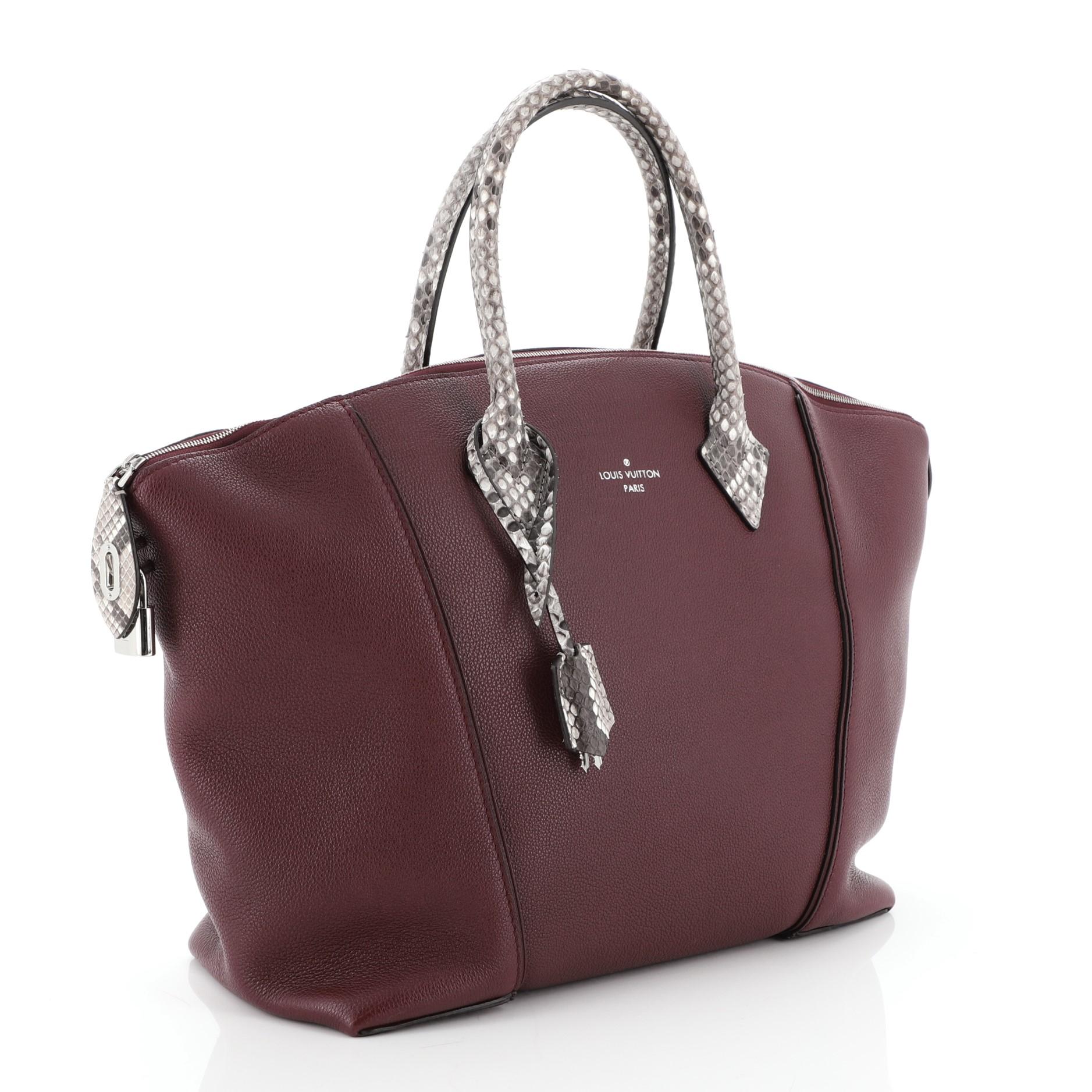 This Louis Vuitton Soft Lockit Handbag Leather with Python MM, crafted from red leather with genuine python, features dual rolled handles, curved top, LV padlock on its side, and silver-tone hardware. Its zip closure opens to a brown suede interior