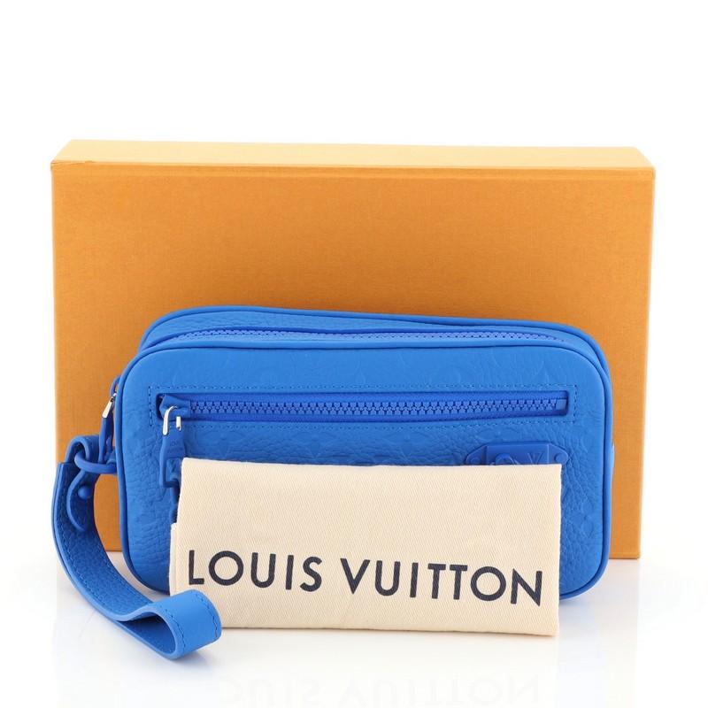 This Louis Vuitton Solar Ray Pochette Volga Monogram Taurillon, crafted in blue monogram taurillon, features a leather hand strap. Its zip closure opens to a blue fabric interior. Authenticity code reads: SP1109. 

Condition: Excellent. Minimal wear