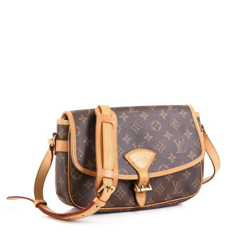 This Louis Vuitton Sologne Handbag Monogram Canvas, crafted from brown monogram coated canvas, features an adjustable vachetta leather shoulder straps with pad, vachetta leather trim, exterior back slip pocket, and gold-tone hardware. Its buckle