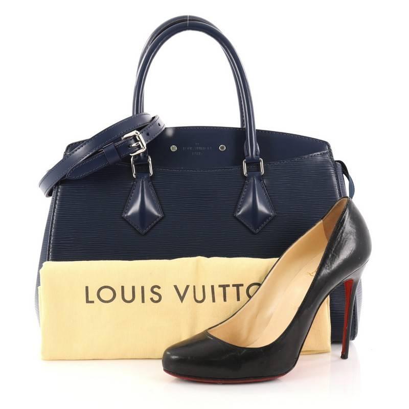 This authentic Louis Vuitton Soufflot NM Handbag Epi Leather MM is a new day-to-day business tote exuding sleek style and versatile functionality. Crafted from blue epi leather, this chic bag features dual-rolled leather handles, smooth leather