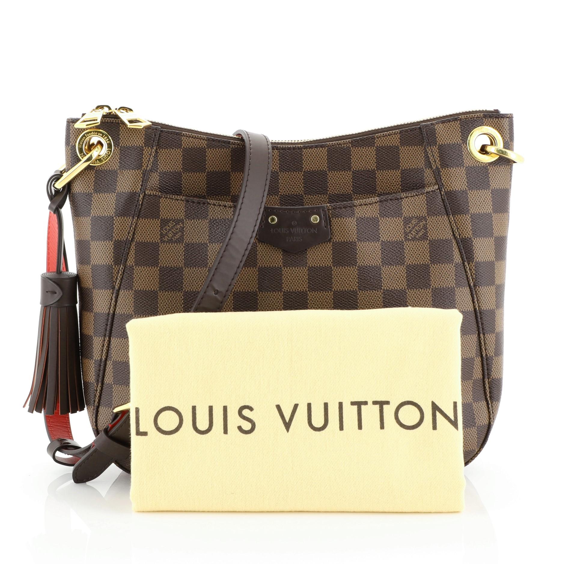 This Louis Vuitton South Bank Besace Bag Damier, crafted in damier ebene coated canvas, features an adjustable leather shoulder strap, leather trim, full facing patch pocket, and gold-tone hardware. Its zip closure opens to a red fabric interior
