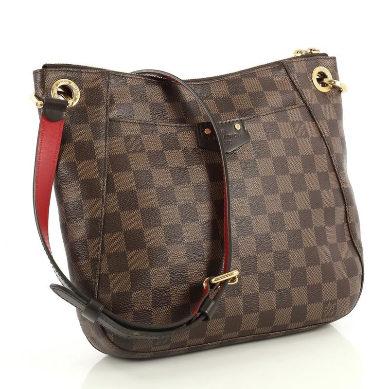 This Louis Vuitton South Bank Besace Bag Damier, crafted in damier ebene coated canvas, features an adjustable leather shoulder strap, dark brown leather trim, full facing patch pocket, and gold-tone hardware. Its zip closure opens to a red fabric