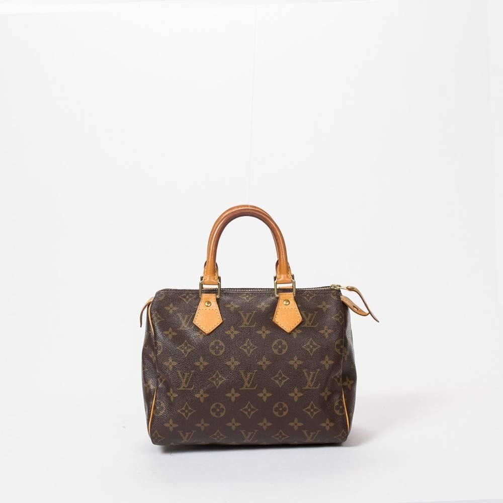 Speedy 25 in brown monogram canvas, with vachetta leather handles, zipper toggle and golden brass hardware.  Brown canvas lining with one pocket. Production code SP1003. Model from 2003. A few scratches on the handles. There are some scuffs on the