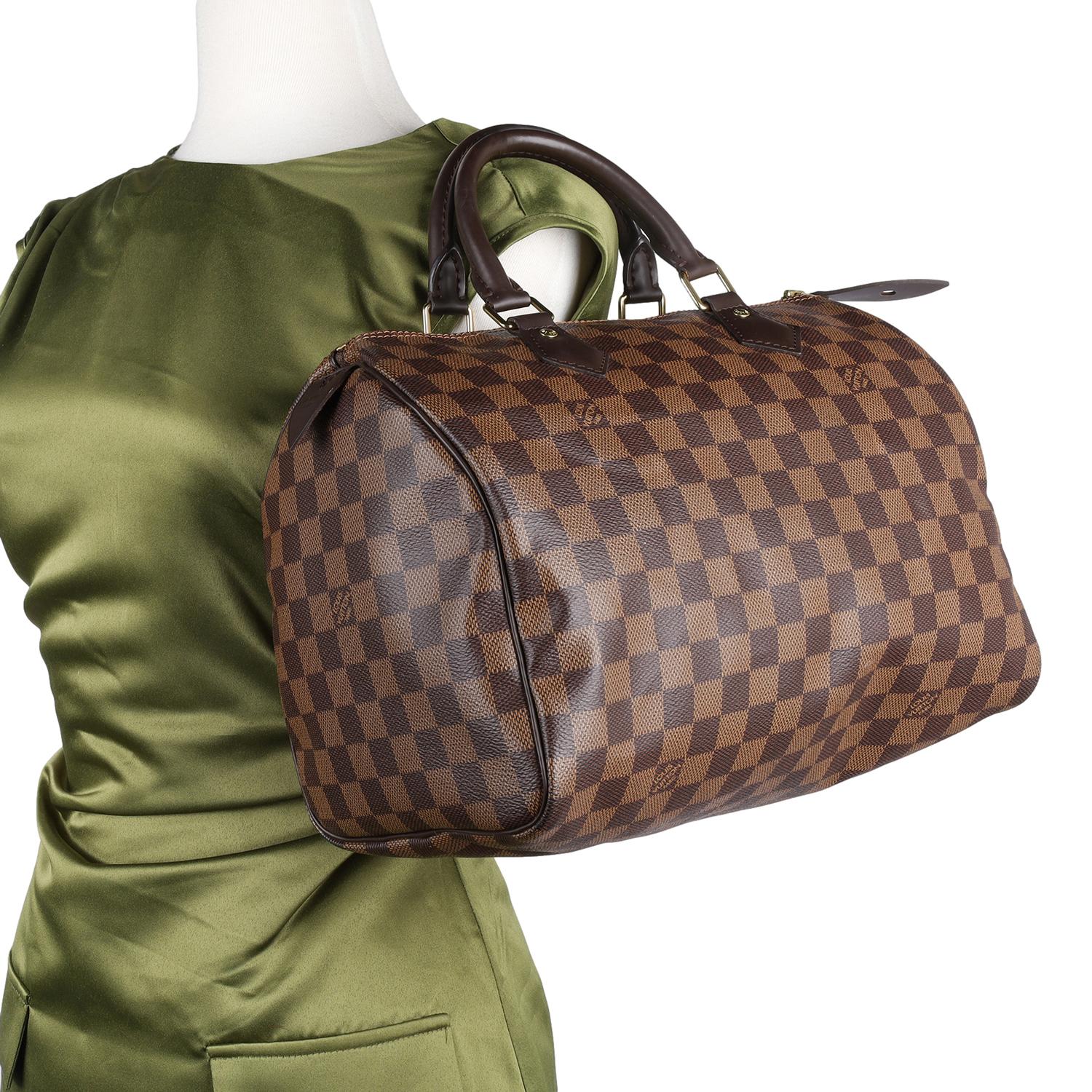 Authentic Louis Vuitton Damier Ebene Speedy 30 satchel. This Speedy is a classic and stylish day to evening bag for city life or traveling. Features damier canvas, dual leather handles, zipper top closure, orange textile interior lining with a