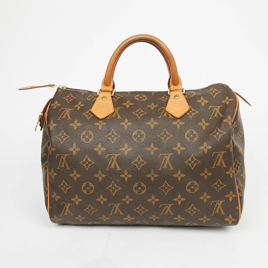 This iconic Speedy bag from the Louis Vuitton House is in ebony Monogram coated canvas lined with brown textile with a flat pocket. The trimmings are in natural cowhide. It can be carried by hand or elbow with its double round handle. The metal