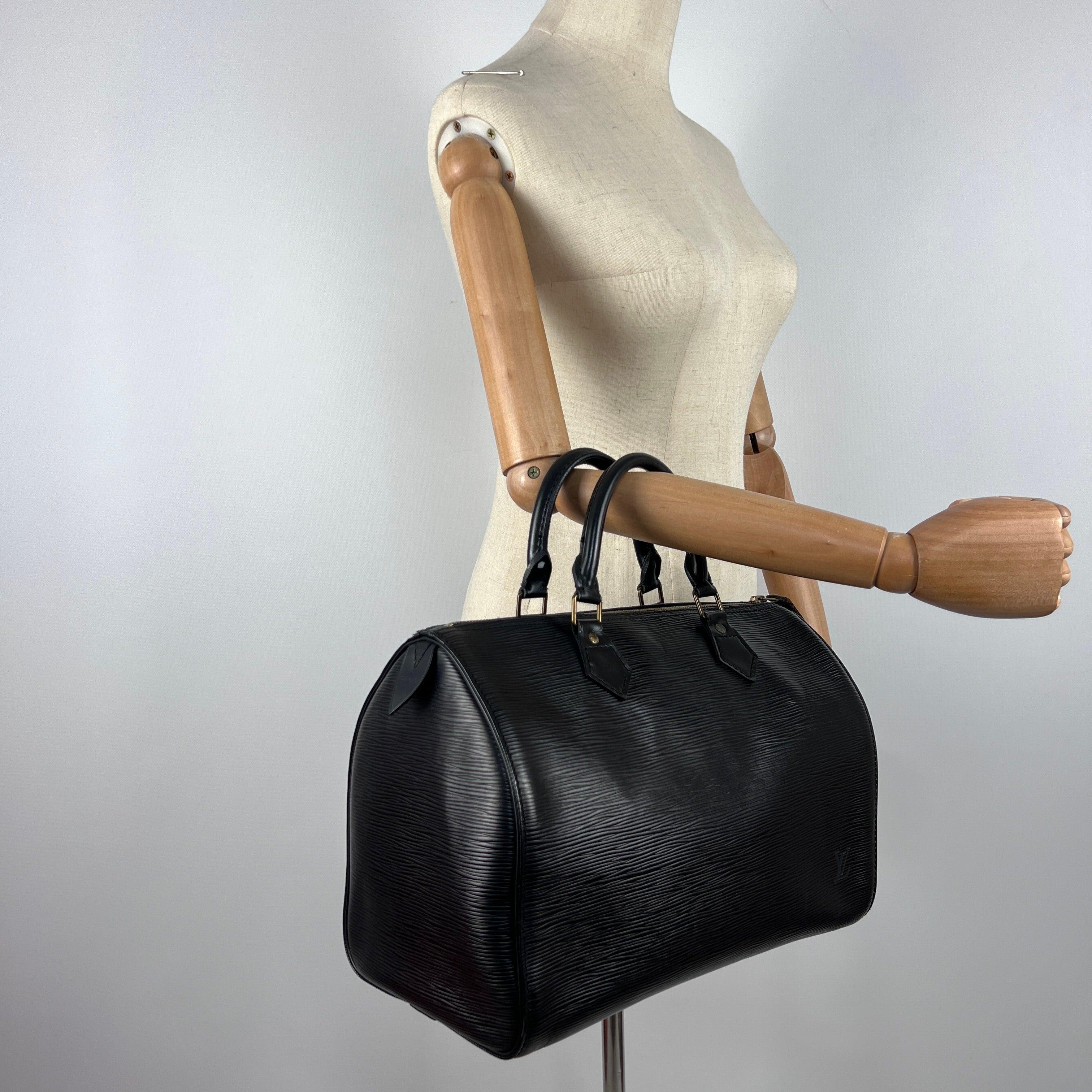 Iconic Speedy 30 in black leather with gold-tone hardware. Zip closure; main compartment with slip pocket. Date code MI0970 (1990), made in France. Hand carry. Condition: very good; lightly worn and well preserved. Dimensions: 32 × 23 × 18 cm.