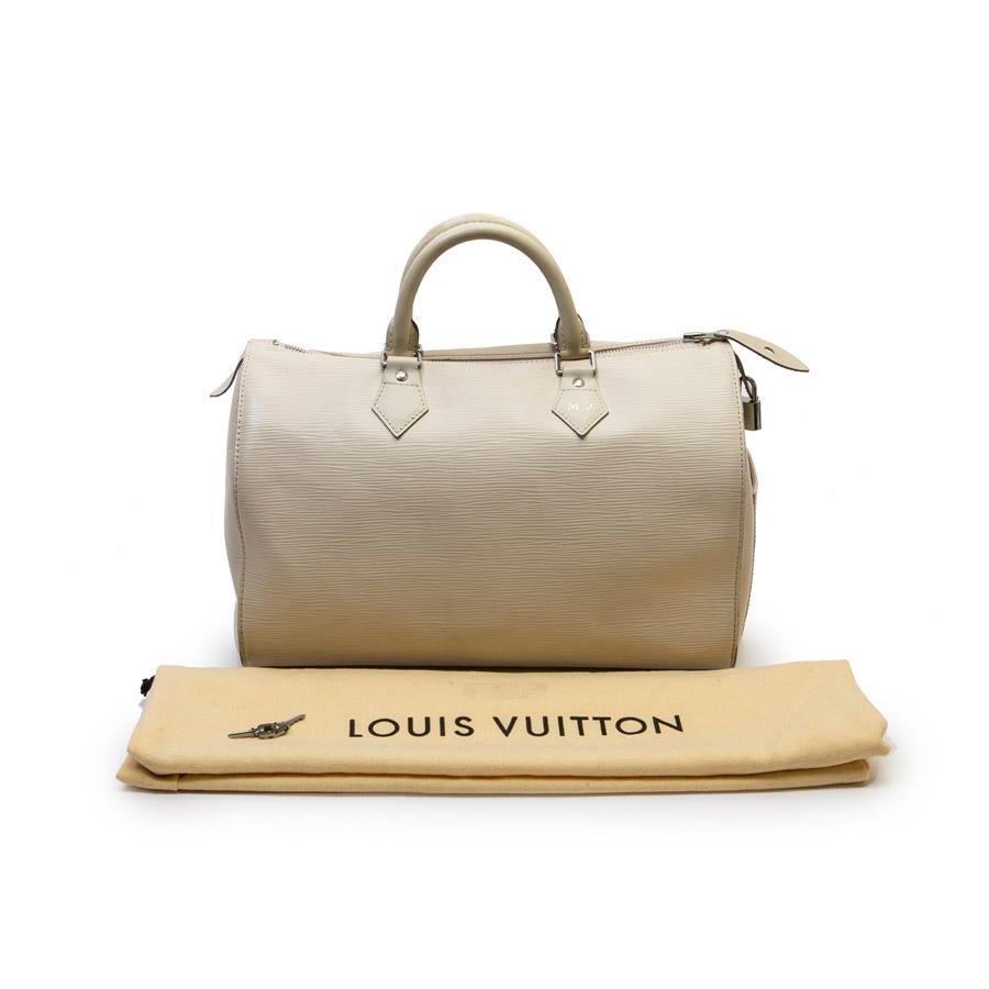 This Louis Vuitton Speedy 35 bag is in ecru epi leather. The jewelry is silver. The closure is zipped. The interior is in beige canvas. It has padlock and keys.
This bag is French made. It dates from 2011 (Serial number). It has initials (M.J). It