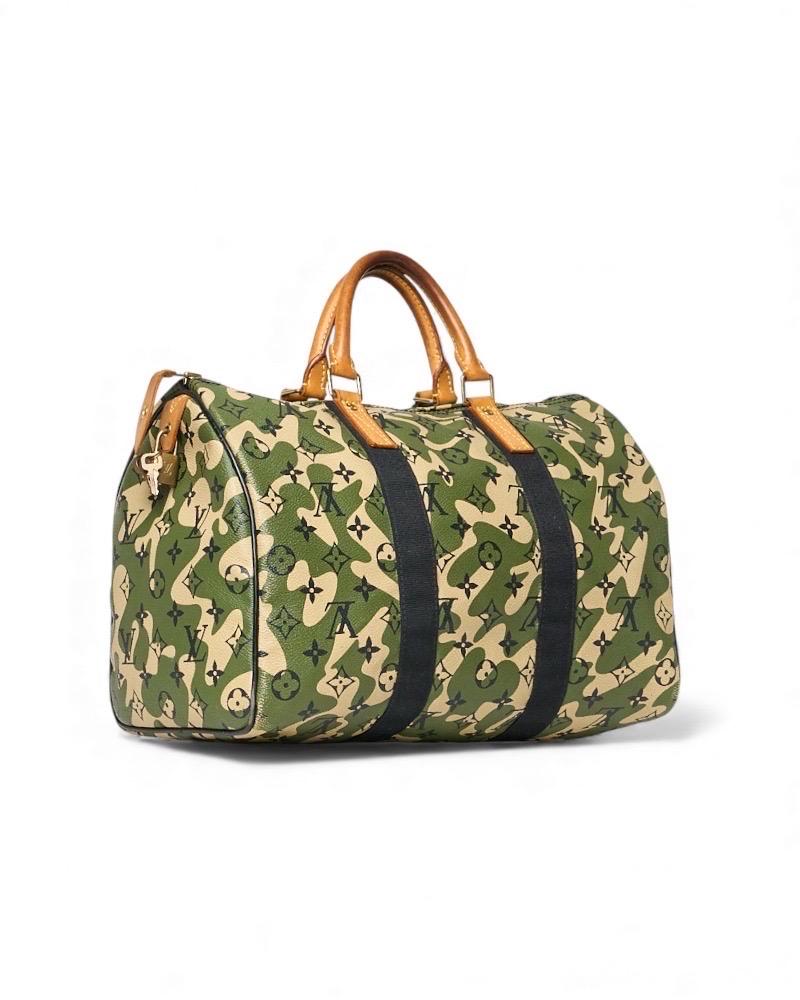 Borsa Louis Vuitton modello Speedy 35, edizione limitata realizzata in collaborazione con l'artista Takashi Murakami. Realizzato in tela monogramouflage nella sofisticata colorazione verde, arricchito da inserti in vacchetta e hardware dorati.