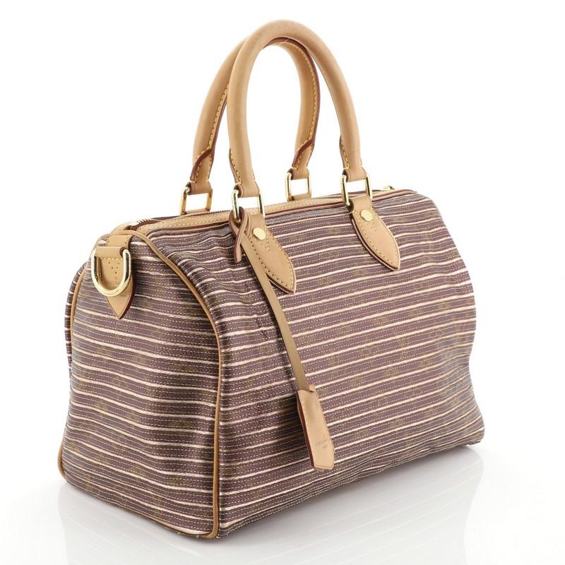 This Louis Vuitton Speedy Bandouliere Bag Limited Edition Monogram Eden 30, crafted from pink monogram eden coated canvas, features dual rolled handles, cowhide leather trim, and gold-tone hardware. Its zip closure opens to a neutral microfiber