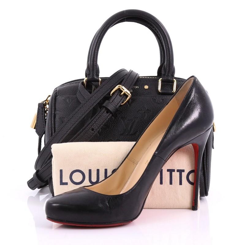 This Louis Vuitton Speedy Bandouliere NM Handbag Monogram Empreinte Leather 20, crafted in black monogram empreinte leather, features dual rolled leather handles, exterior slip pockets, and gold-tone hardware. Its zip closure opens to a gray fabric